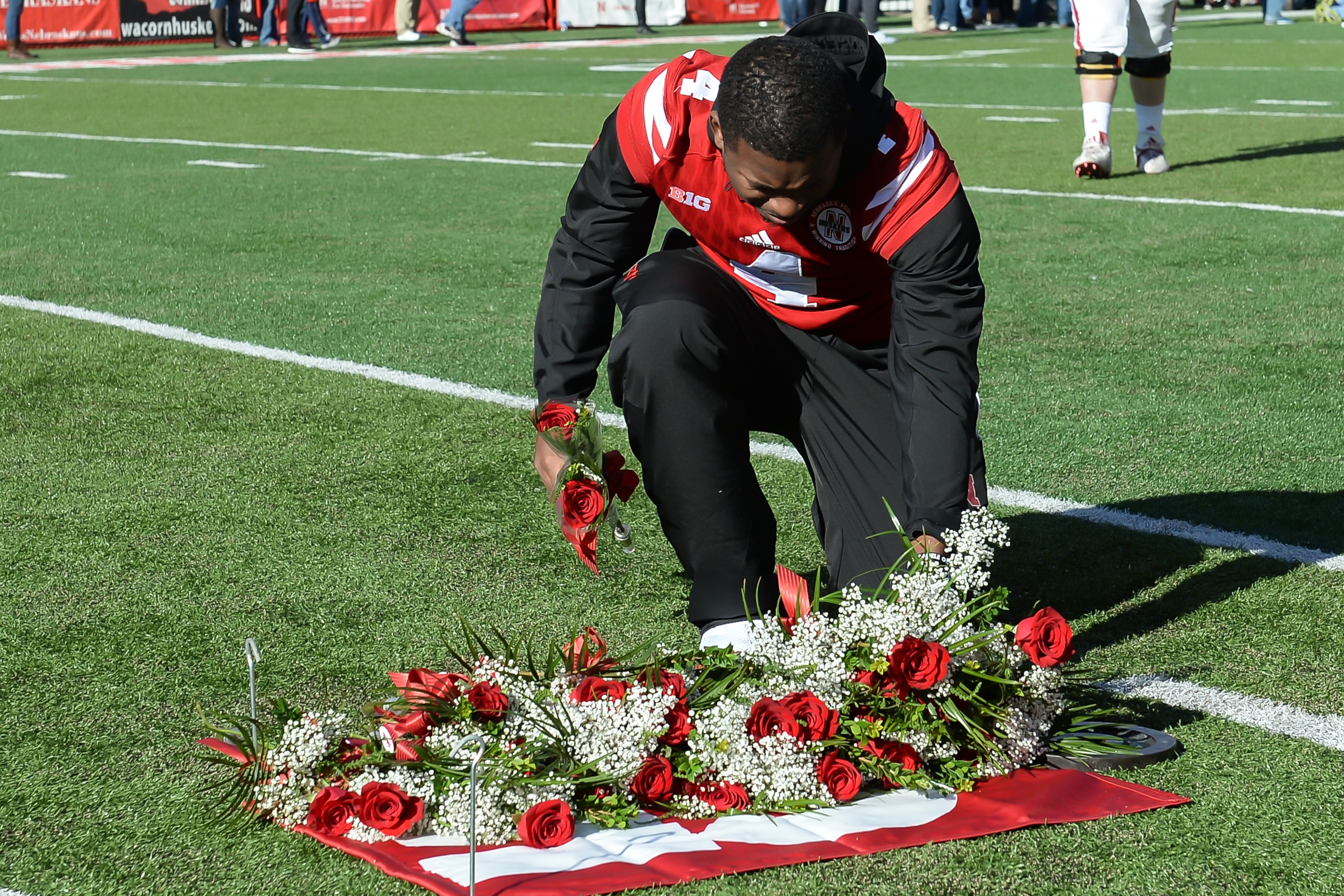 LINCOLN, NE - NOVEMBER 19: Quarterback Tommy Armstrong Jr. #4 of the Nebraska Cornhuskers places a rose in memory of deceased player Sam Foltz before the game against the Maryland Terrapins at Memorial Stadium on November 19, 2016 in Lincoln, Nebraska. (P