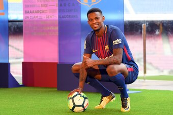 Barcelona's new player Portuguesse Nelson Semedo poses with his new jersey and a ball during his official presentation, after signing his new contract with the Catalan club at the Camp Nou stadium in Barcelona on July 14, 2017. / AFP PHOTO / LLUIS GENE   