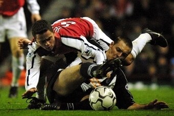 LONDON, UNITED KINGDOM:  Arsenal's Juan (L) tussles with Grimsby Town's Paul Groves (R) in The Worthington Cup 4th round match at Highbury in London 27 November 2001. Arsenal's Brazilian player Edu scored an early first half goal to put Arsenal ahead 1-0 