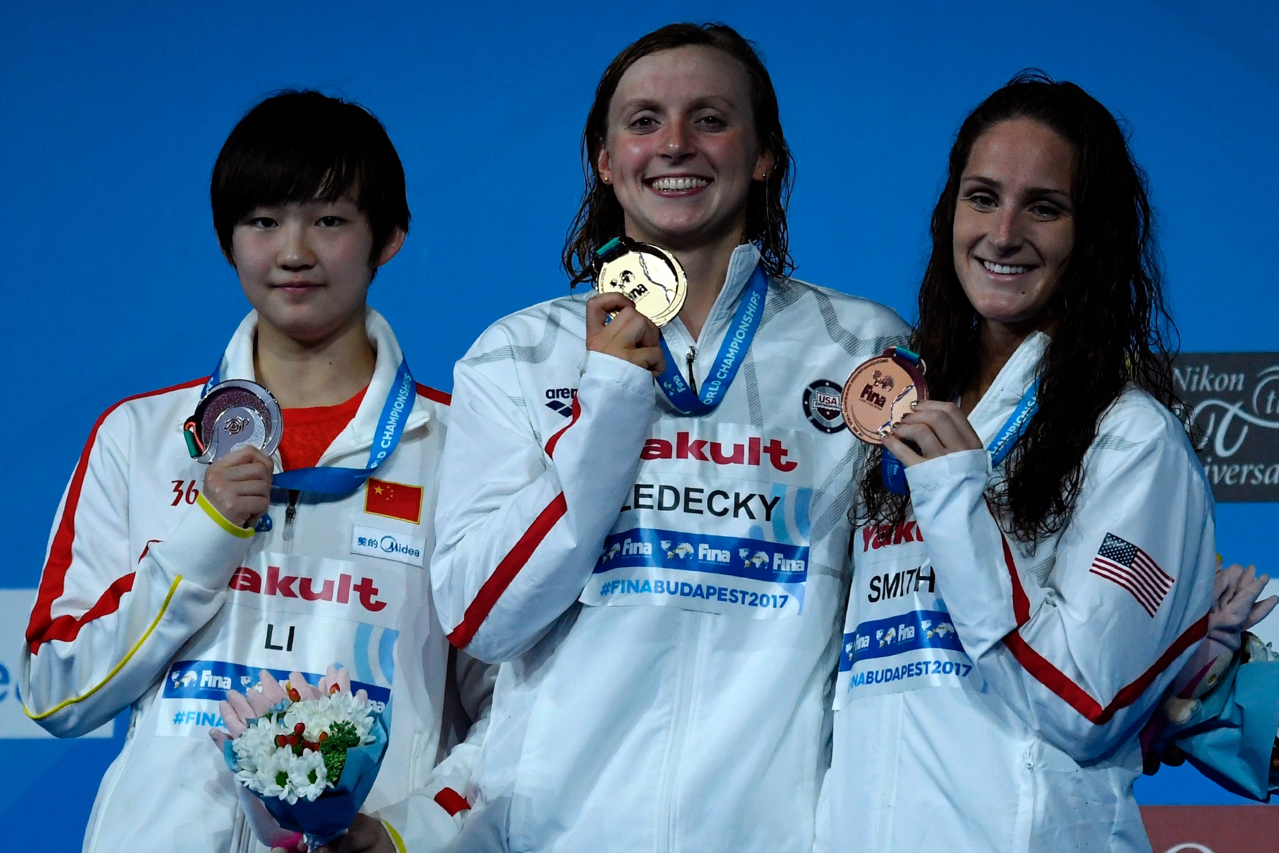 (L-R) China's Li Bingjie, US Katie Ledecky and US Leah Smith celebrate on the podium after the women's 800m freestyle final during the swimming competition at the 2017 FINA World Championships in Budapest, on July 29, 2017.  / AFP PHOTO / CHRISTOPHE SIMON