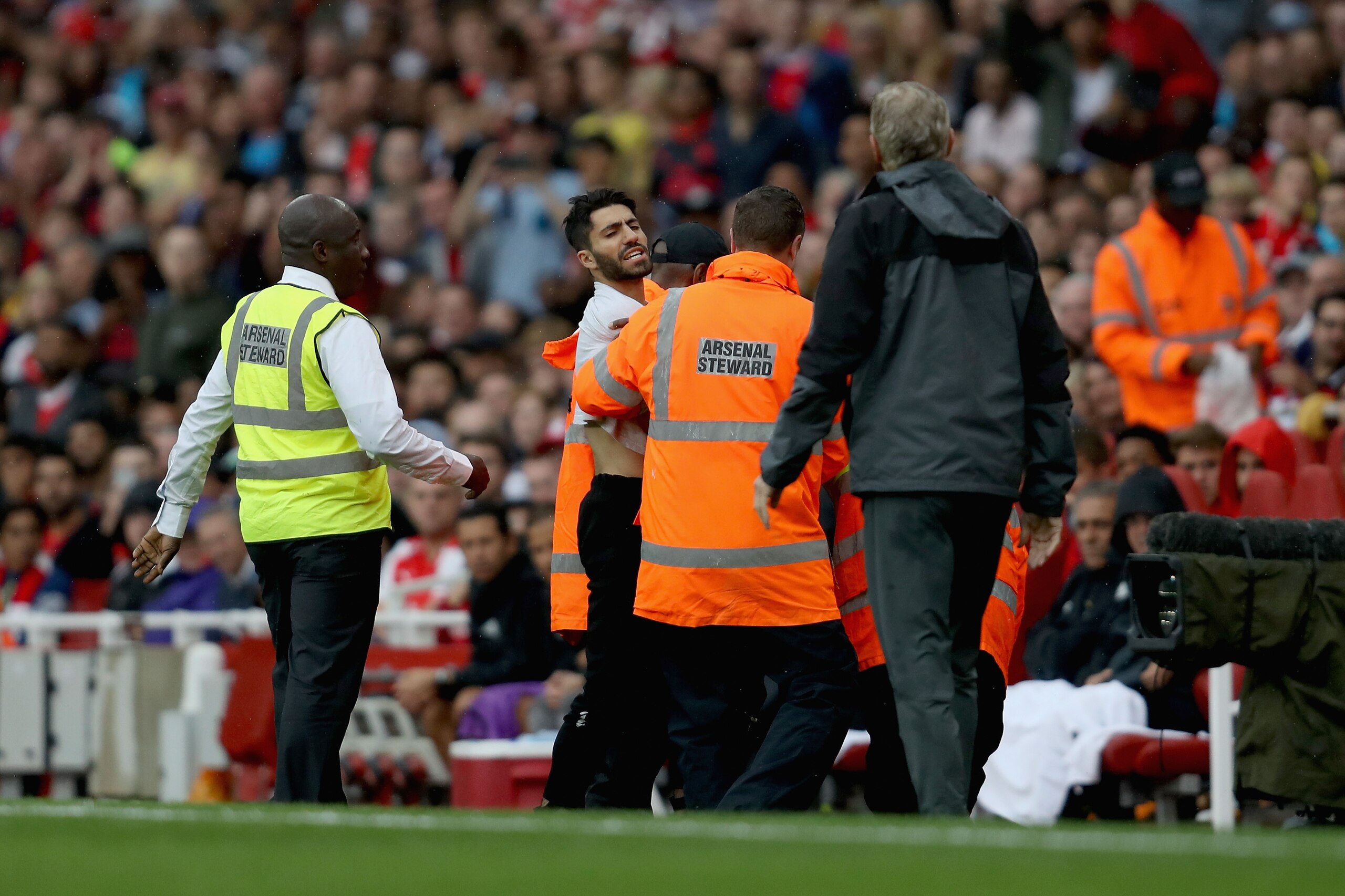 LONDON, ENGLAND - JULY 29: A pitch invader shouts at coach Arsène Wenger of Arsenal during the pre-season friendly match between Arsenal v SL Benfica during the Emirates Cup at Emirates Stadium on July 29, 2017 in London, England.  (Photo by Linnea Rhebor