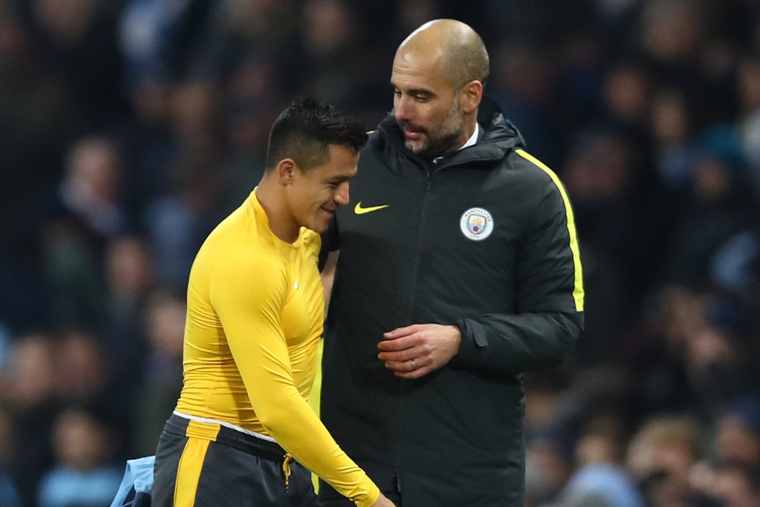MANCHESTER, ENGLAND - DECEMBER 18: Alexis Sanchez of Arsenal (L) and Josep Guardiola, Manager of Manchester City (R) embrace after the final whistle during the Premier League match between Manchester City and Arsenal at the Etihad Stadium on December 18, MANCHESTER, ENGLAND - DECEMBER 18: Alexis Sanchez of Arsenal (L) and Josep Guardiola, Manager of Manchester City (R) embrace after the final whistle during the Premier League match between Manchester City and Arsenal at the Etihad Stadium on December 18,
