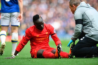 Liverpool's Senegalese midfielder Sadio Mane reacts as he receives medical attention after picking up an injury during the English Premier League football match between Liverpool and Everton at Anfield in Liverpool, north west England on April 1, 2017. / 