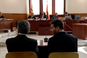 Barcelona's football star Lionel Messi (R) and his father Jorge Horacio Messi listen as they face judges in a tax fraud case at the courthouse of Barcelona on June 2, 2016.
The 28-year-old football star was cheered and jeered as he emerged from a van acco