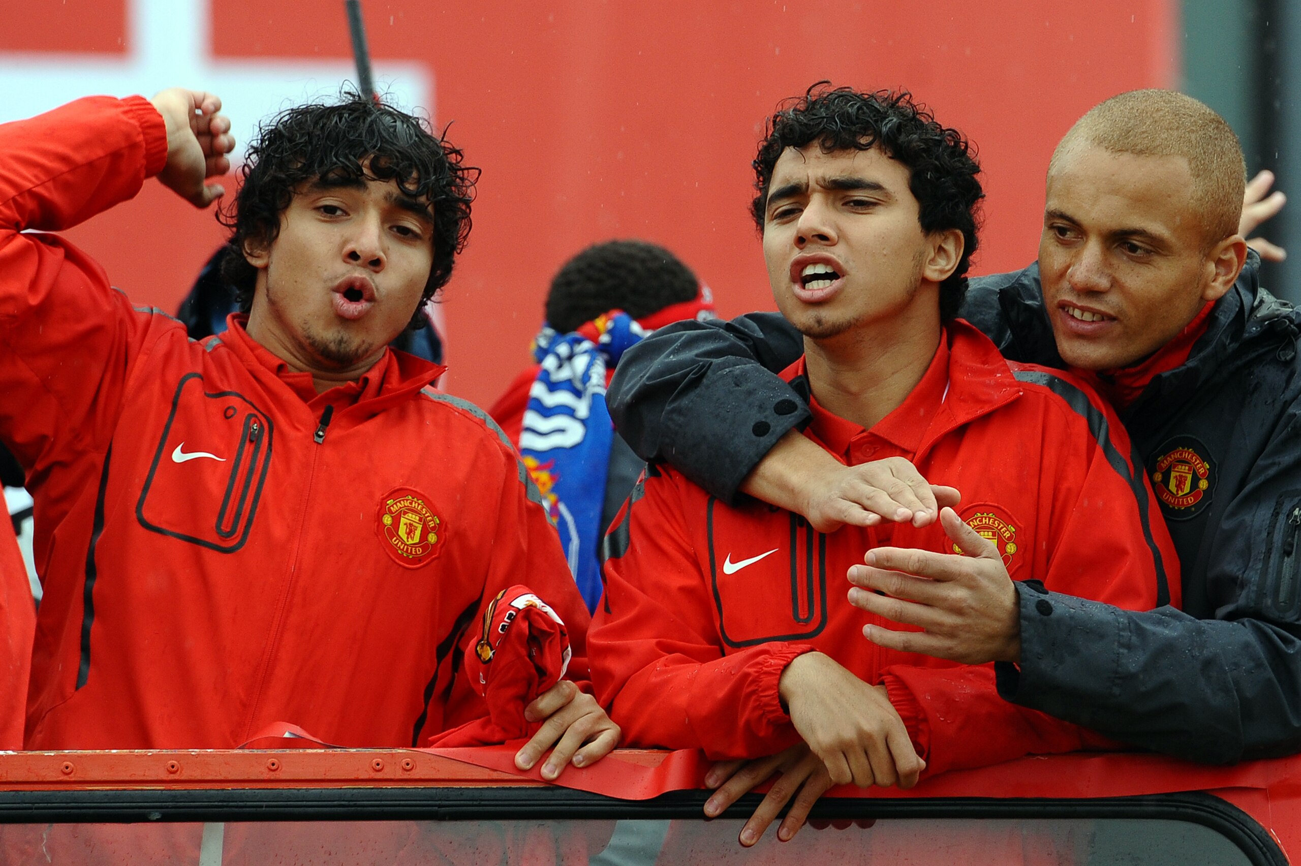(From L) Manchester United's Brazilian defender Rafael Da Silva, Brazilian defender Fabio Da SIlva and English defender Wes Brown wave as Manchester United supporters welcome a bus carrying the players and officials at Old Trafford in Manchester, north we