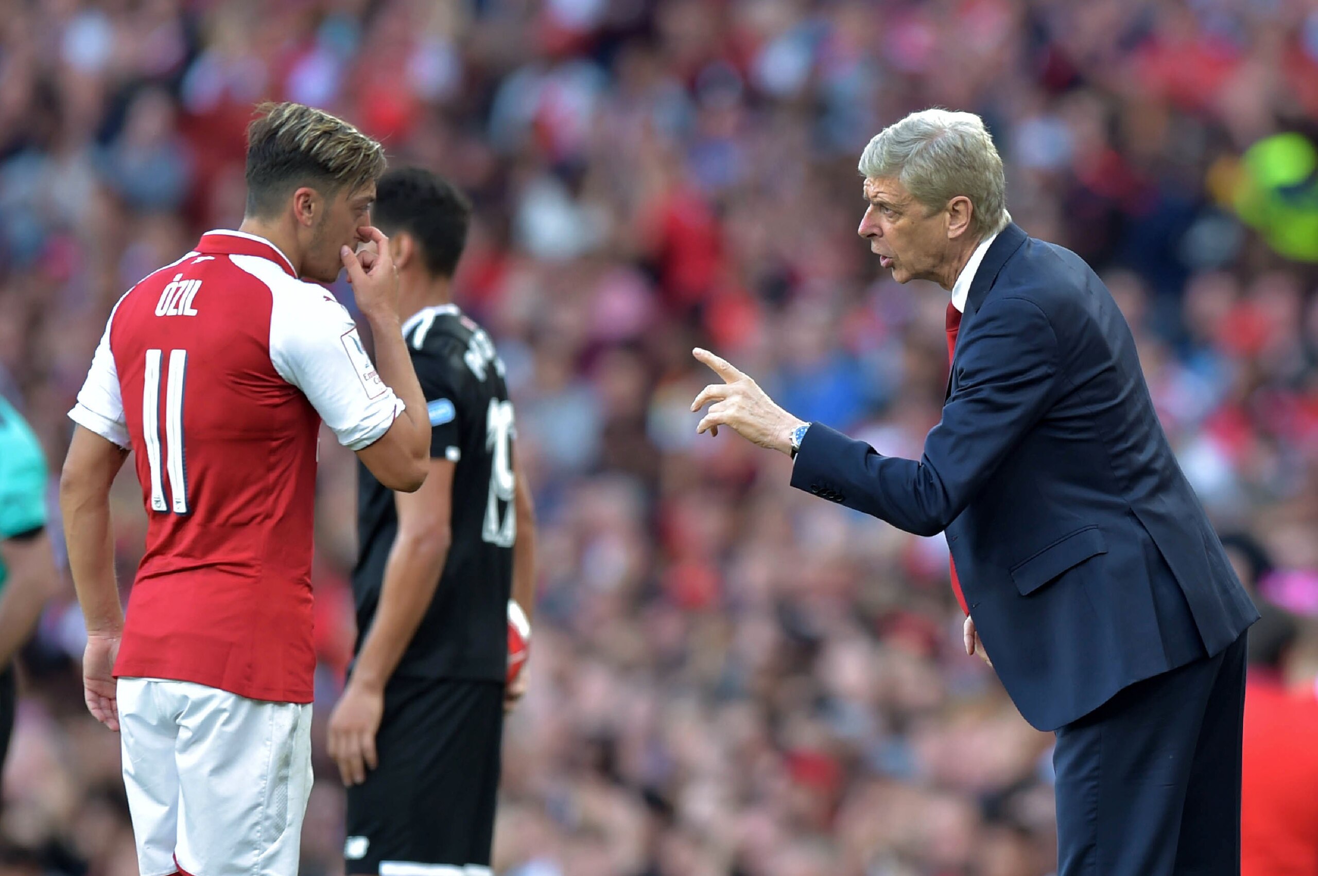 Arsenal's French manager Arsene Wenger (R) interacts with Arsenal's German midfielder Mesut Ozil during the pre-season friendly football match between Arsenal and Sevilla at The Emirates Stadium in north London on July 30, 2017, the game is one of four ma