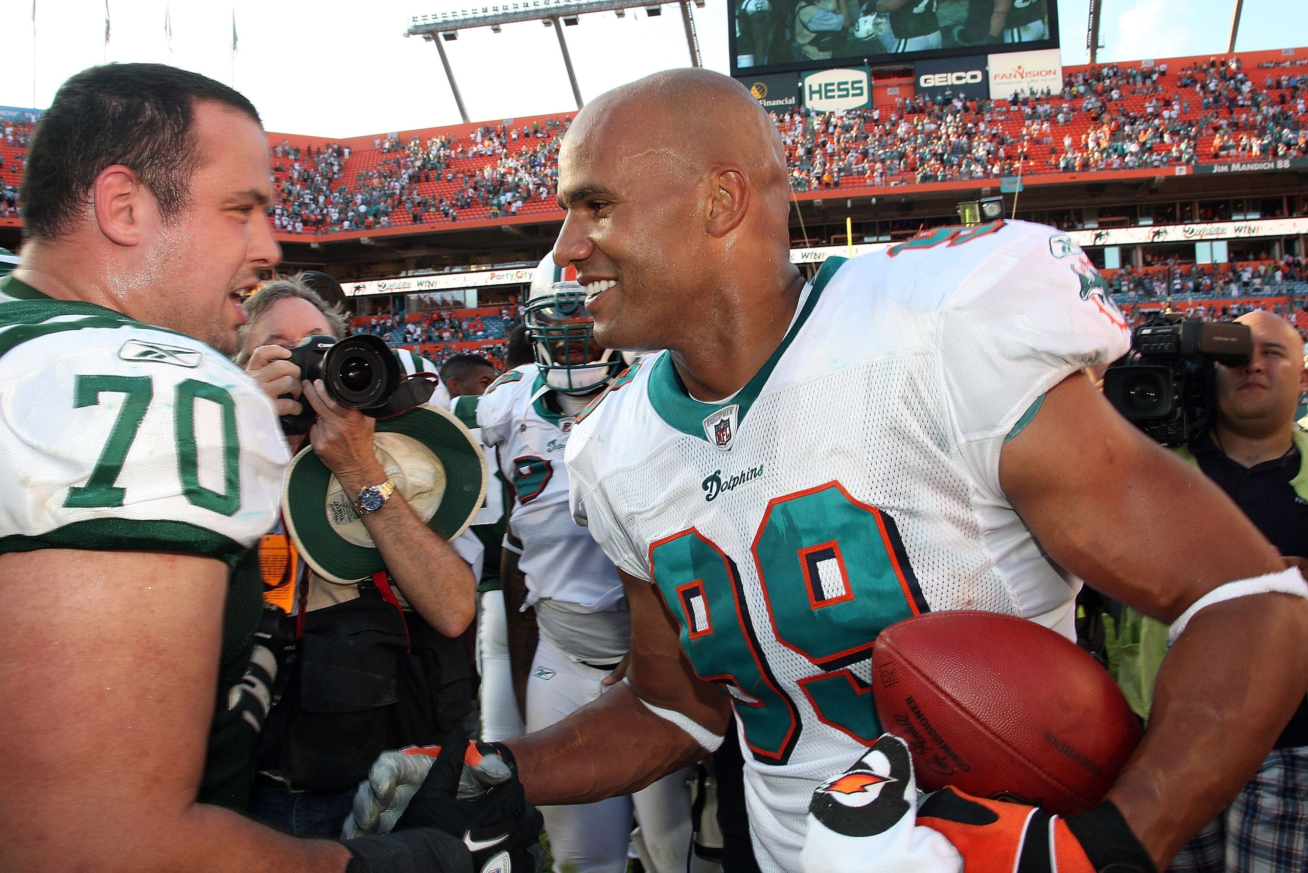 MIAMI GARDENS, FL - JANUARY 01:  Linebacker Jason Taylor #99 of the Miami Dolphins is congratulated by Defensive End Mike DeVito #70 of the New York Jets after his last game at Sun Life Stadium on January 1, 2012 in Miami Gardens, Florida.  (Photo by Al P