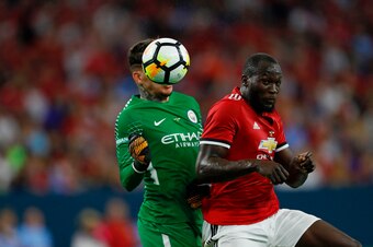 Manchester United forward Romelu Lukaku (R) hits a header past Manchester City goalkeeper Ederson Moraes (L) during the International Champions Cup soccer match at NRG Stadium on July 20, 2017 in Houston, Texas. Manchester United won 2-0. / AFP PHOTO / AA