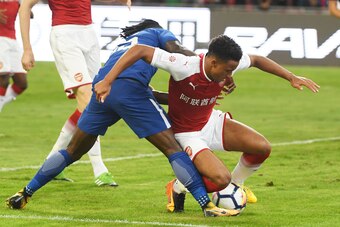 Chelsea's Victor Moses (L) challenges Arsenal's Cohen Bramall during their friendly football match at Beijing's National Stadium, known as the Bird's Nest, on July 22, 2017. / AFP PHOTO / GREG BAKER        (Photo credit should read GREG BAKER/AFP/Getty Im