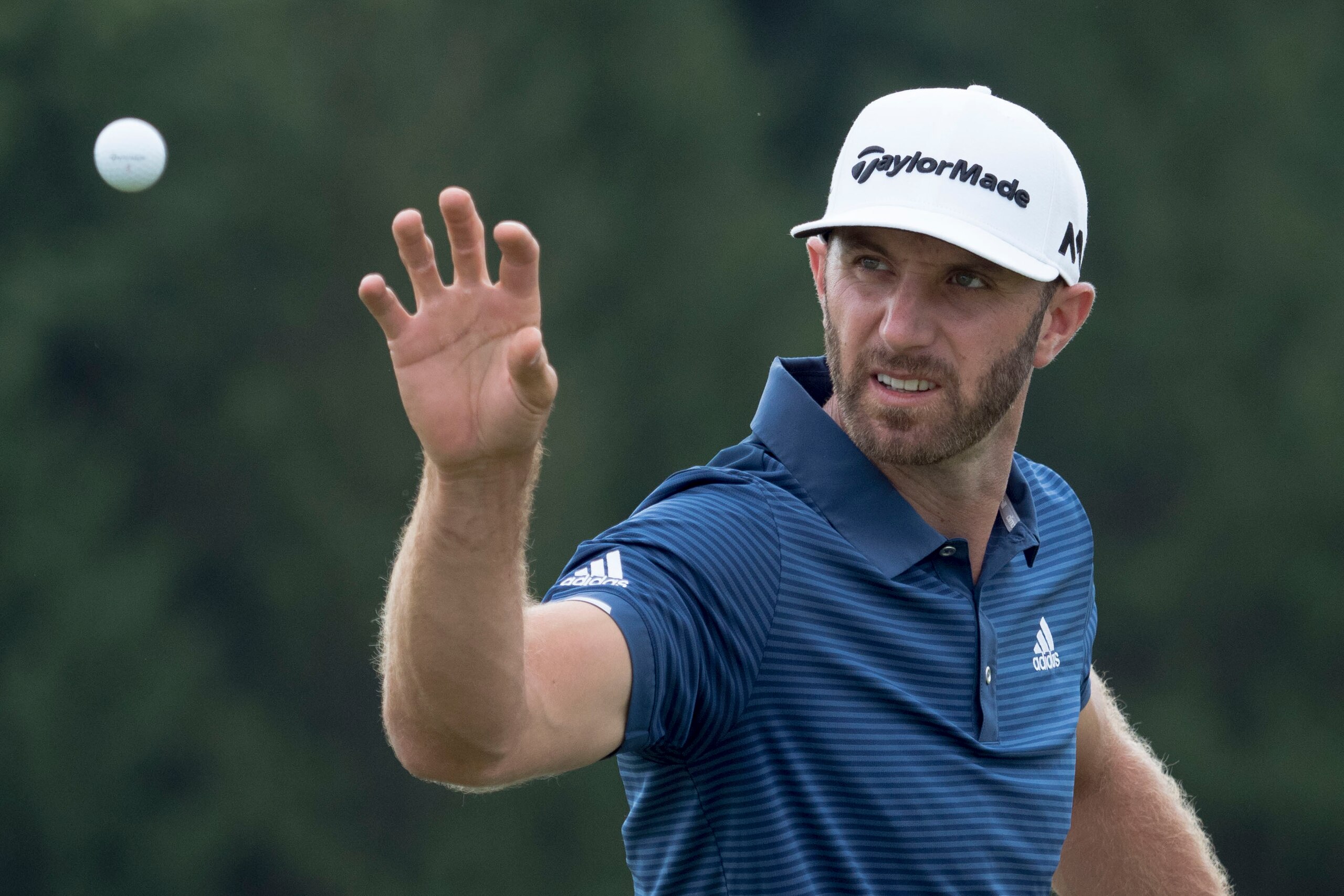 August 6, 2017; Akron, OH, USA; Dustin Johnson catches a golf ball on the driving range during the final round of the WGC - Bridgestone Invitational golf tournament at Firestone Country Club - South Course. Mandatory Credit: Kyle Terada-USA TODAY Sports