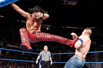Shinsuke Nakamura nails John Cena with a flying kick.
