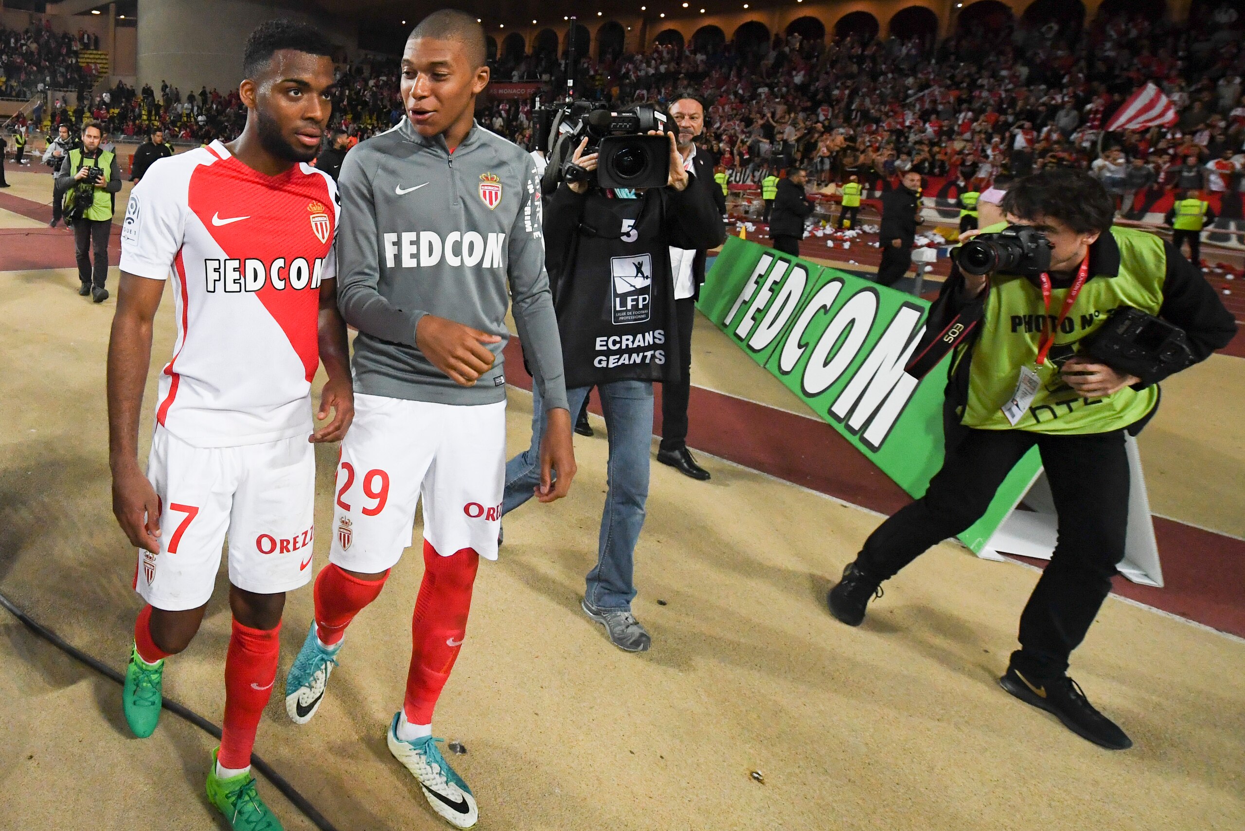 Monaco's French midfielder  Thomas Lemar (L) and foward Kylian Mbappe Lottin celebrate their victory at the end of the French L1 football match between Monaco (ASM) and Lille (LOSC) at the Louis II Stadium in Monaco on May 14,2017. / AFP PHOTO / Yann COAT