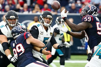 HOUSTON, TX - JANUARY 03: J.J. Watt #99 of the Houston Texans strips the ball from Blake Bortles #5 of the Jacksonville Jaguars into the hands of Whitney Mercilus #59 of the Houston Texans for an interception in the fourth quarter on January 3, 2016 at NR