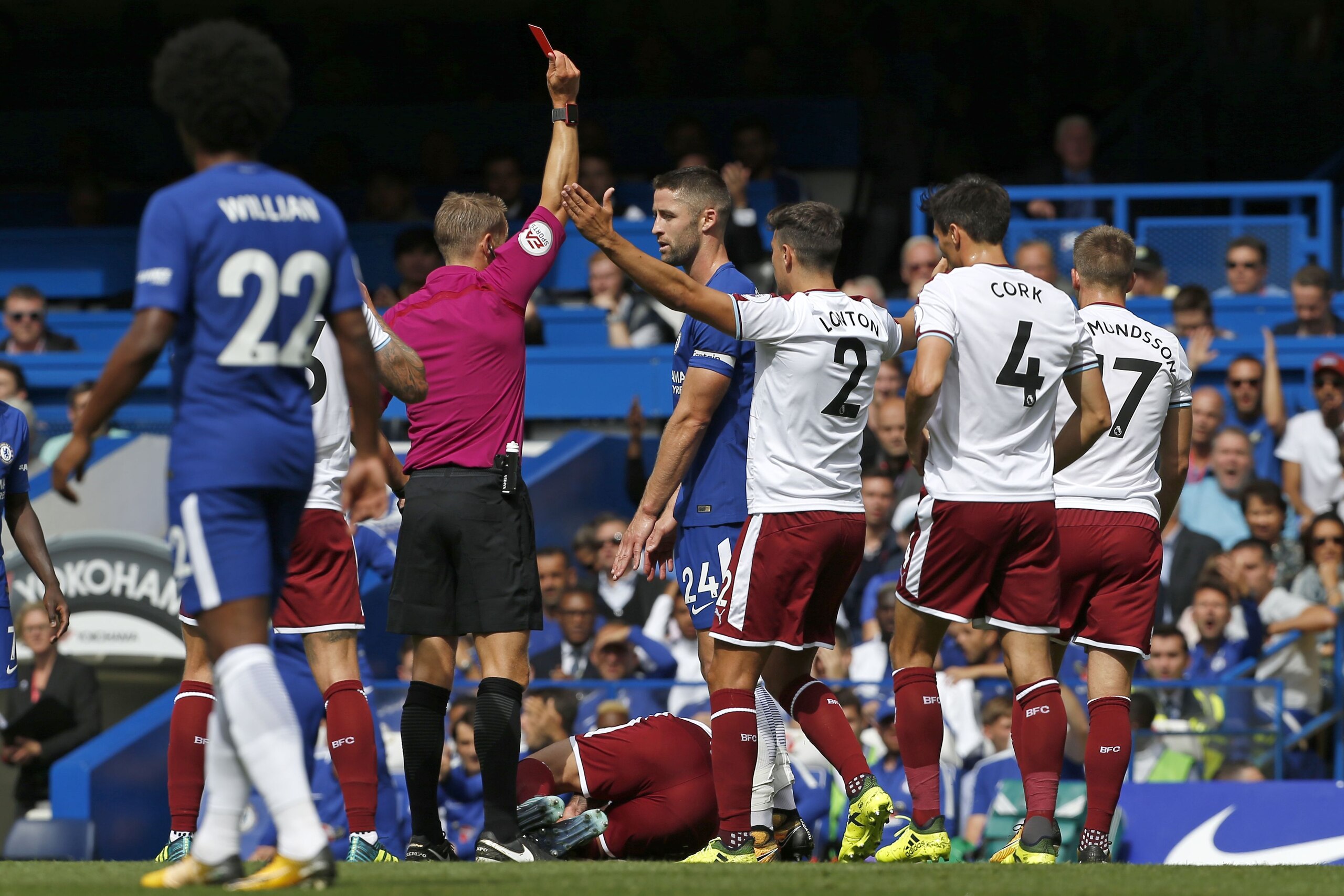 Chelsea's English defender Gary Cahill (C) is shown a red card by English referee Craig Pawson after a foul on Burnley's Belgian midfielder Steven Defour during the English Premier League football match between Chelsea and Burnley at Stamford Bridge in Lo