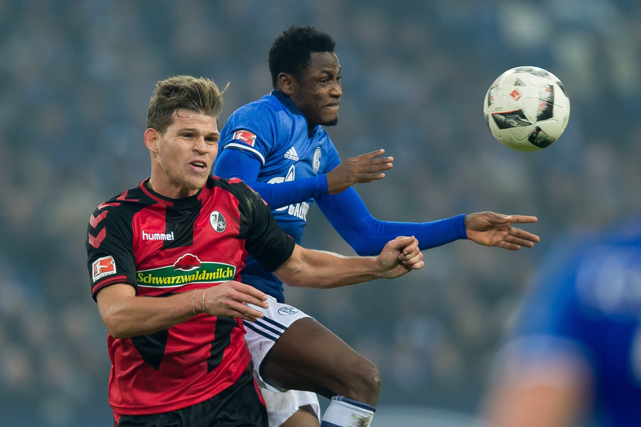 GELSENKIRCHEN, GERMANY - DECEMBER 17: Florian Niederlechner of Freiburg and Abdul Rahman Baba of Schalke battle for the ball during the Bundesliga match between FC Schalke 04 and SC Freiburg at Veltins-Arena on December 17, 2016 in Gelsenkirchen, Germany.