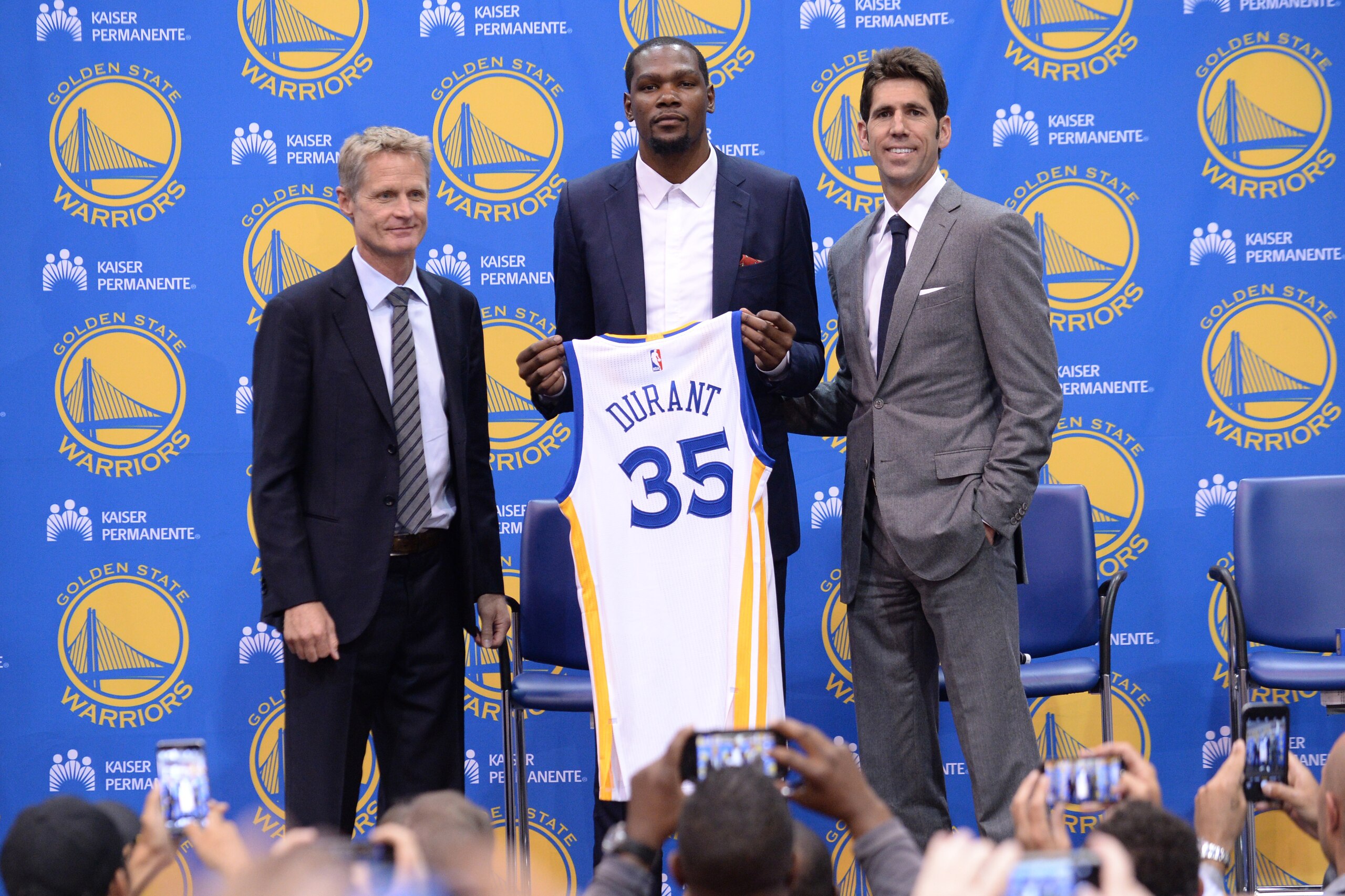 OAKLAND, CA - JULY 7:  Head coach Steve Kerr of the Golden State Warriors, Kevin Durant and General Manager Bob Myers display the jersey of Kevin Durant #35 Golden State Warriors during the press conference to introduce Kevin Durant on July 7, 2016 in Oak