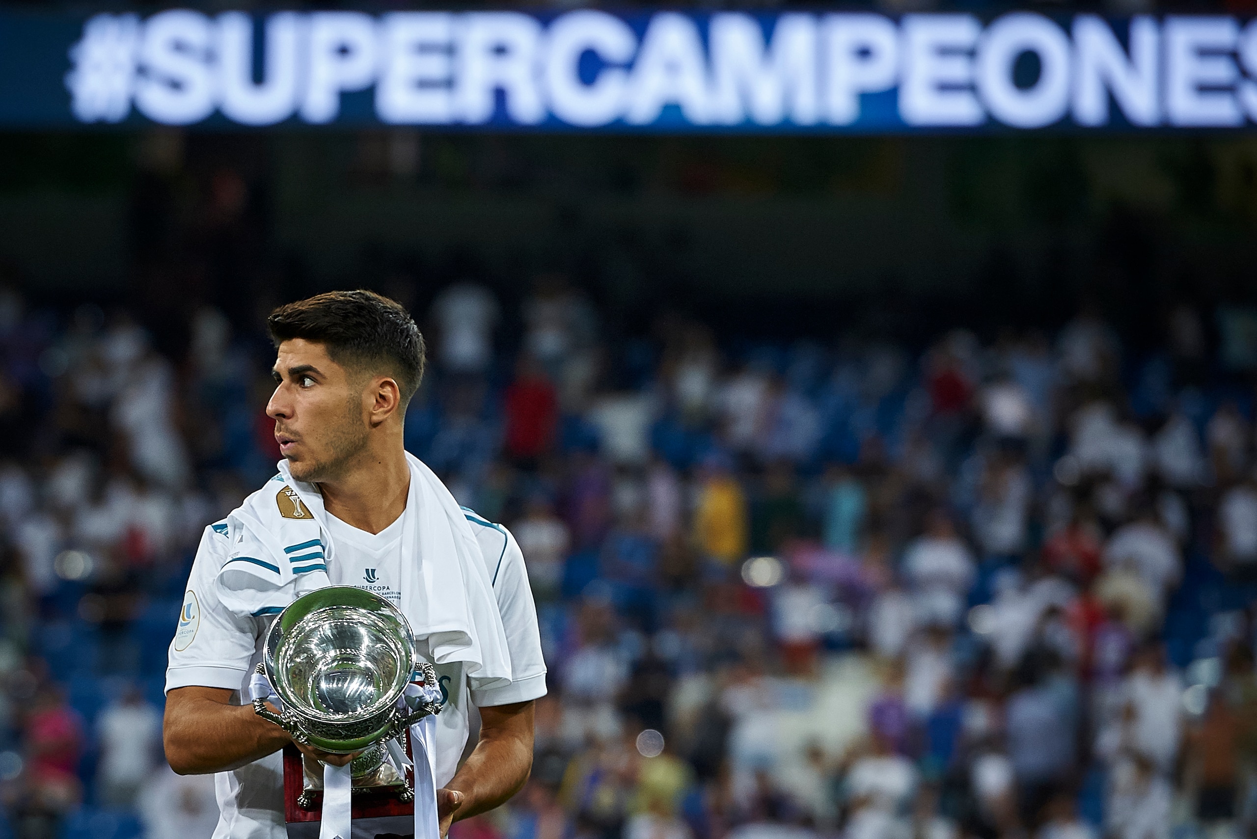 MADRID, SPAIN - AUGUST 16:  Marco Asensio of Real Madrid celebrates with the trophy after winning the Supercopa de Espana Supercopa Final 2nd Leg match between Real Madrid and FC Barcelona at Estadio Santiago Bernabeu on August 16, 2017 in Madrid, Spain. 