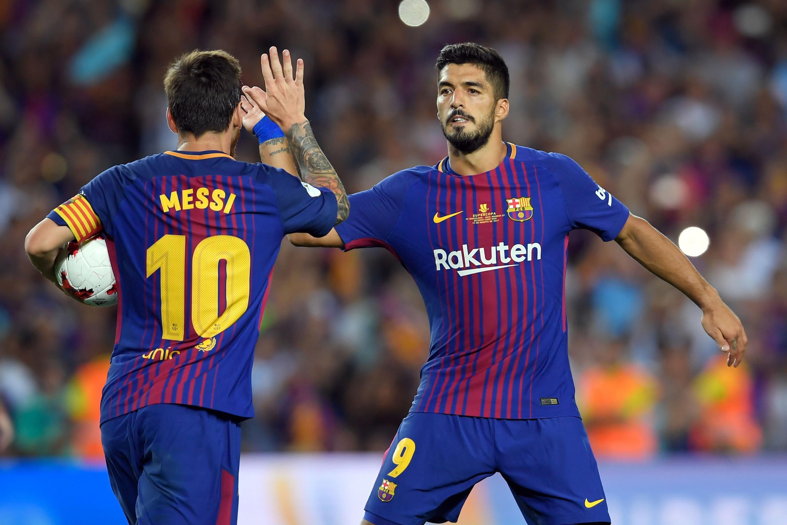 Barcelona's Argentinian forward Lionel Messi (L) celebrates with Barcelona's Uruguayan forward Luis Suarez after scoring a goal following a penalty kick during the Spanish Supercup first leg football match FC Barcelona vs Real Madrid at the Camp Nou stadi