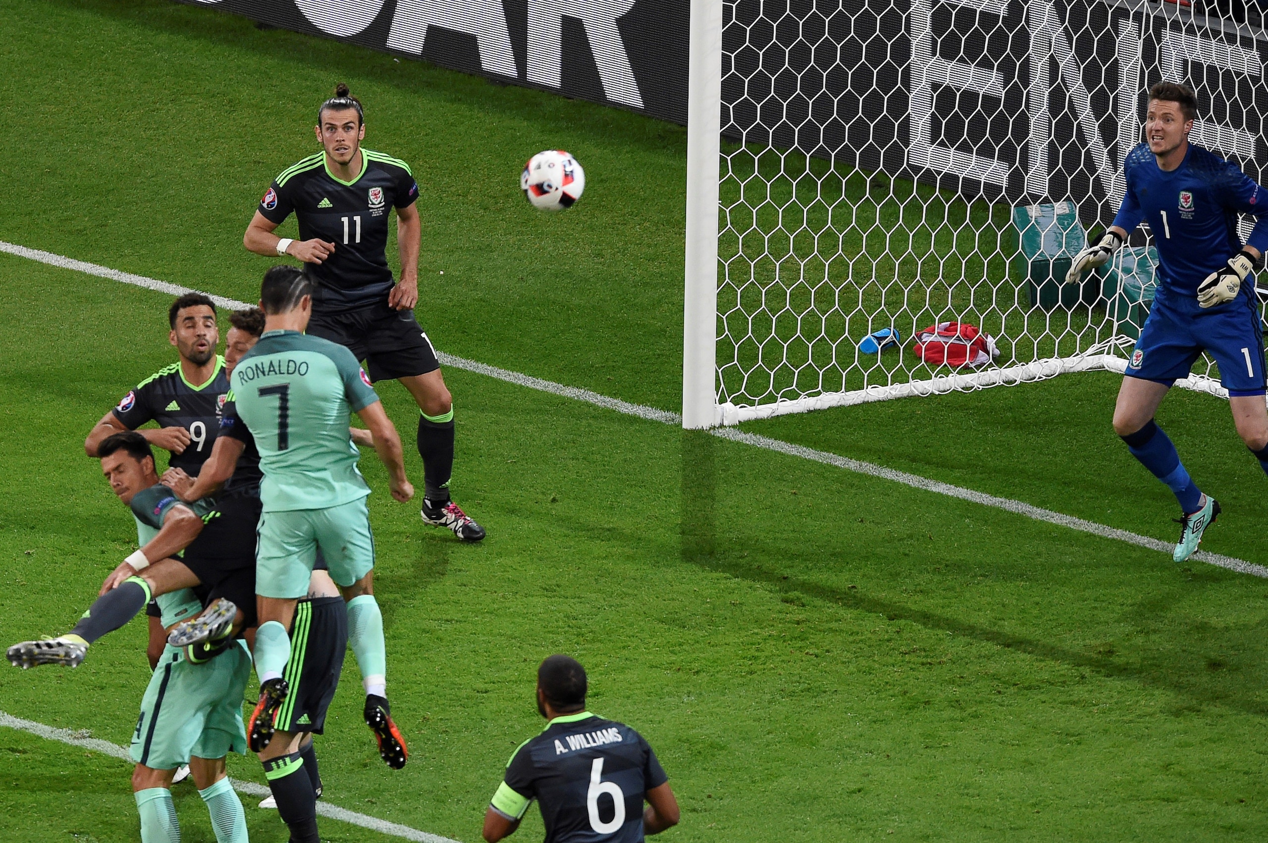 Portugal's forward Cristiano Ronaldo (3L) scores the opening goal past Wales' goalkeeper Wayne Hennessey (R) during the Euro 2016 semi-final football match between Portugal and Wales at the Parc Olympique Lyonnais stadium in Décines-Charpieu, near Lyon, o