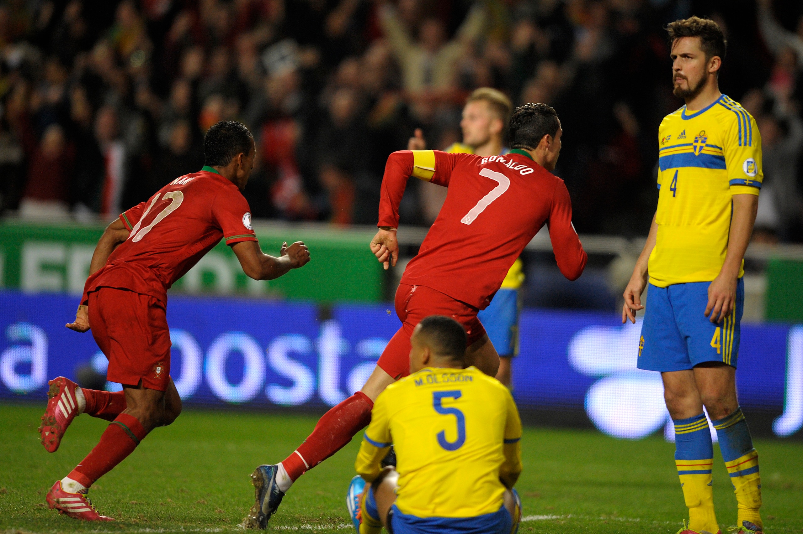 Portugal's forward Cristiano Ronaldo (C) celebrates his goal next to Sweden's defender Per Nilsson (R) during the FIFA 2014 World Cup qualifier play-off first leg football match Portugal vs Sweden at the Luz stadium in Lisbon on November 15, 2013.  Portug