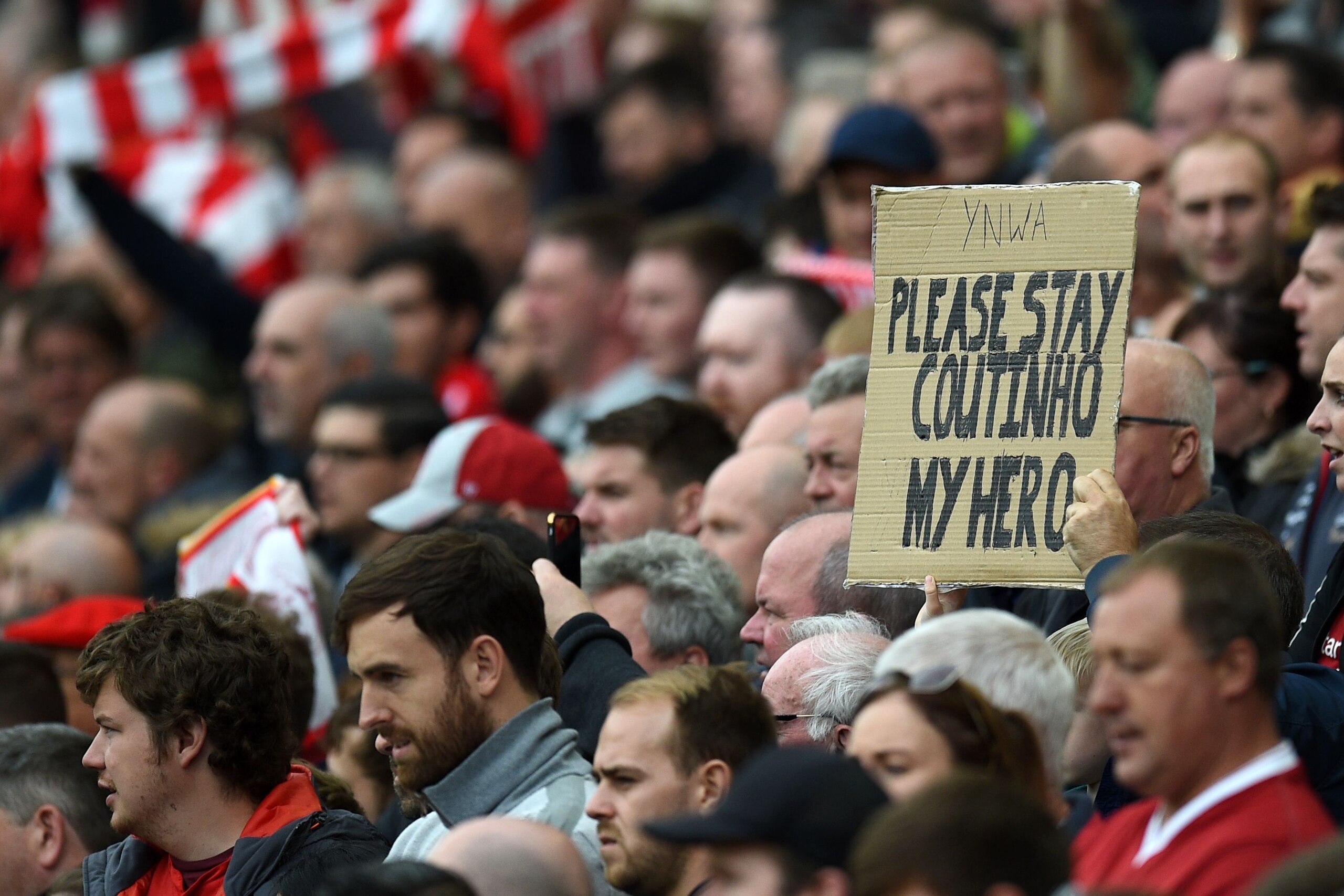 A fan holds up a placard in support of Liverpool's Brazilian midfielder Philippe Coutinho during the English Premier League football match between Liverpool and Crystal Palace at Anfield in Liverpool, north west England on August 19, 2017. / AFP PHOTO / O