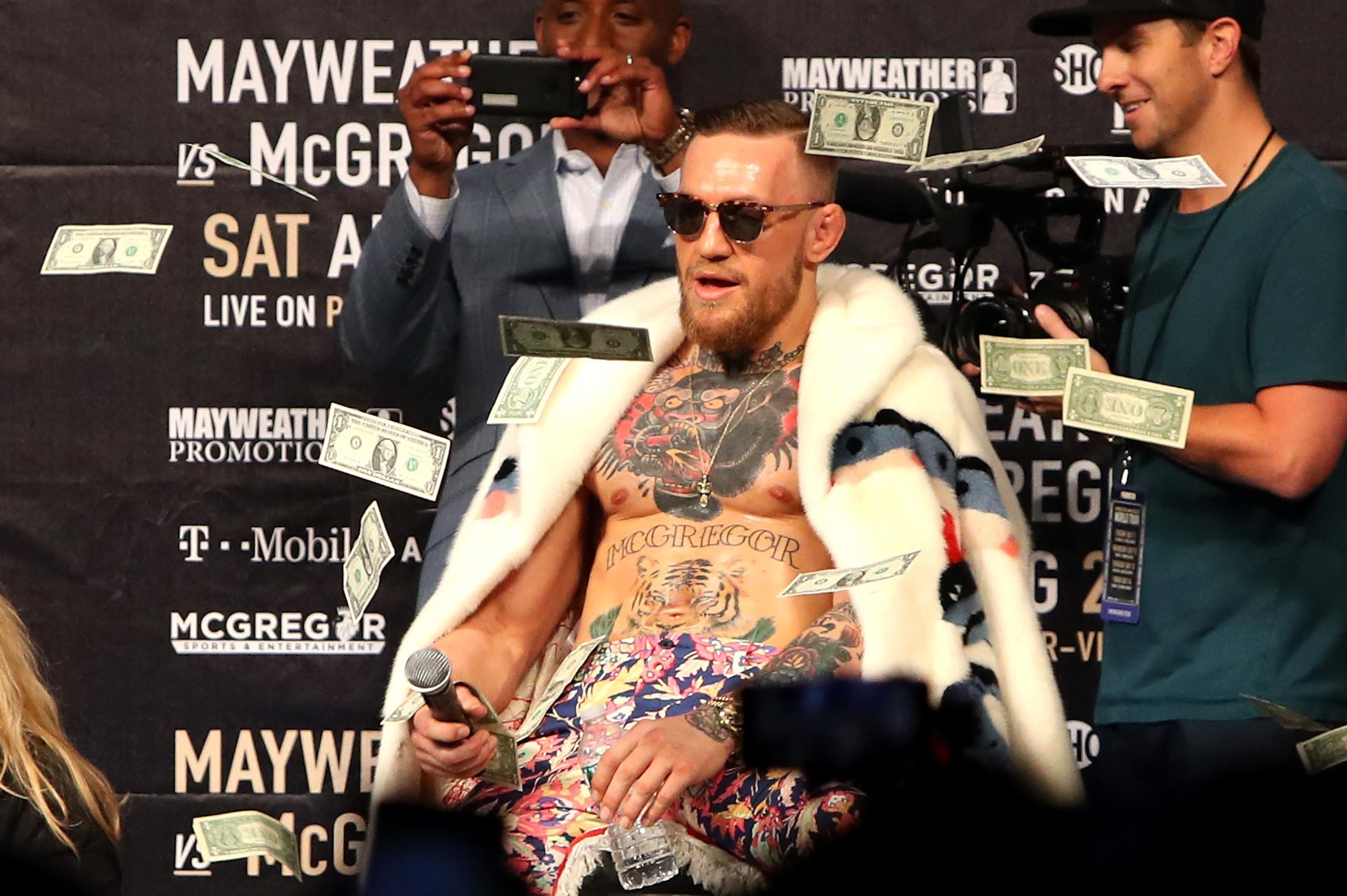 NEW YORK, NY - JULY 13:  Conor McGregor looks on as money rains down during the Floyd Mayweather Jr. v Conor McGregor World Press Tour event at Barclays Center on July 13, 2017 in the Brooklyn borough of New York City.  (Photo by Mike Lawrie/Getty Images)