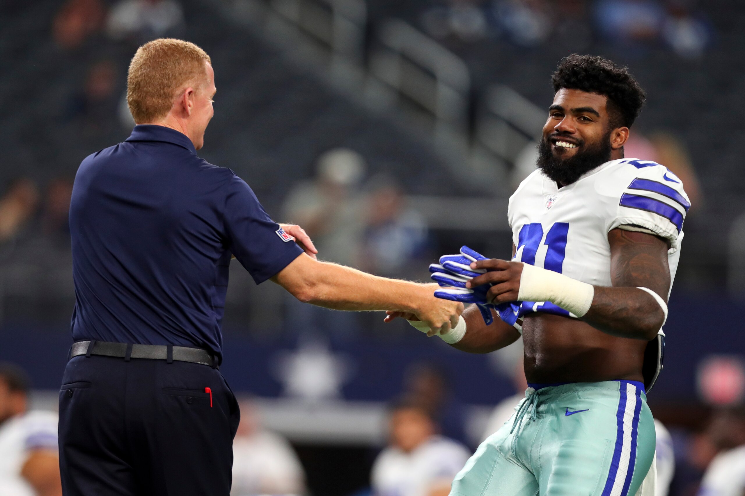 ARLINGTON, TX - AUGUST 19: Head coach Jason Garrett of the Dallas Cowboys jokes with Ezekiel Elliott #21 of the Dallas Cowboys during warmups before the preseason game against the Indianapolis Colts at AT&T Stadium on August 19, 2017 in Arlington, Texas. 