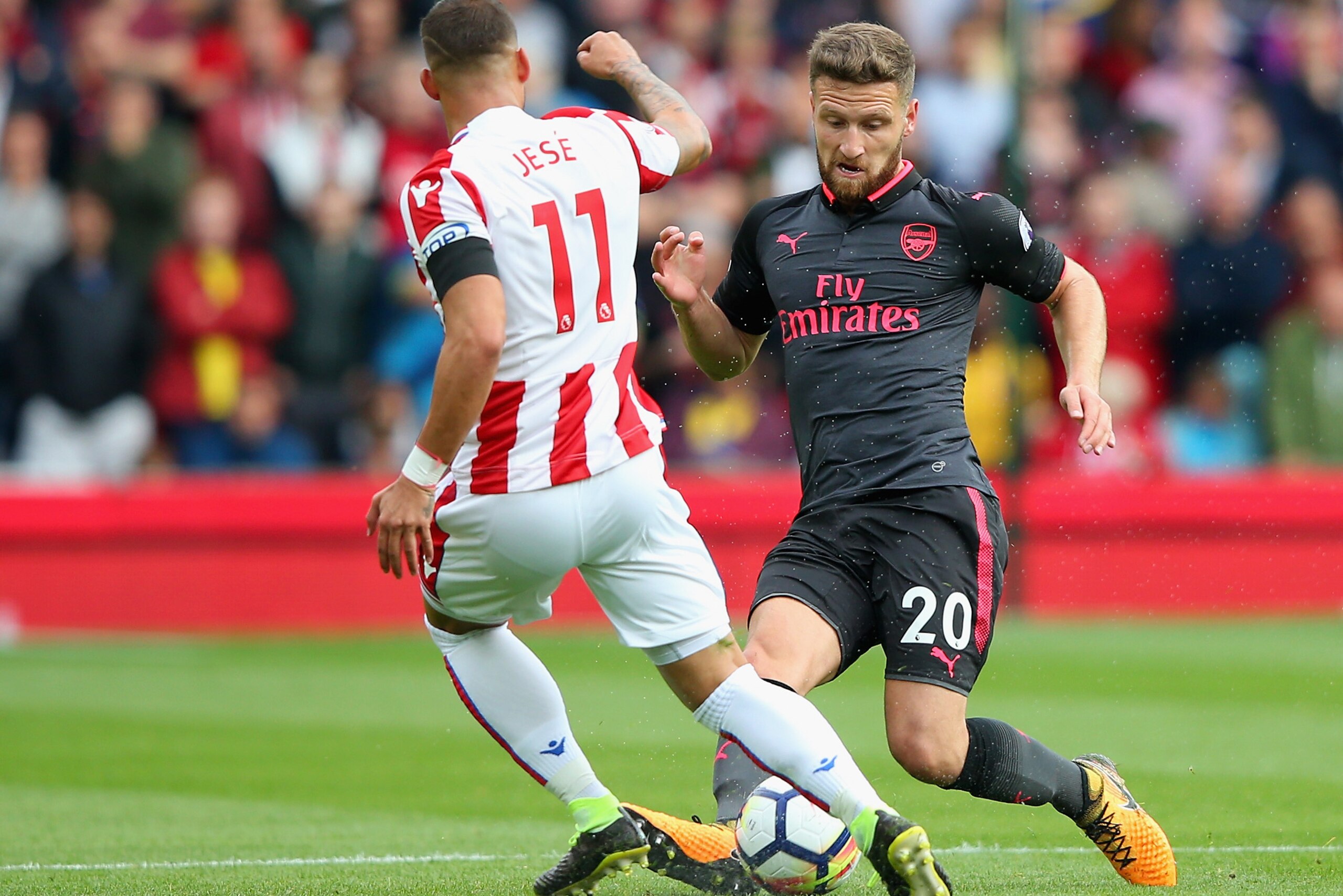 STOKE ON TRENT, ENGLAND - AUGUST 19: Jese of Stoke City and Shkodran Mustafi of Arsenal battle for possession during the Premier League match between Stoke City and Arsenal at Bet365 Stadium on August 19, 2017 in Stoke on Trent, England.  (Photo by Alex L