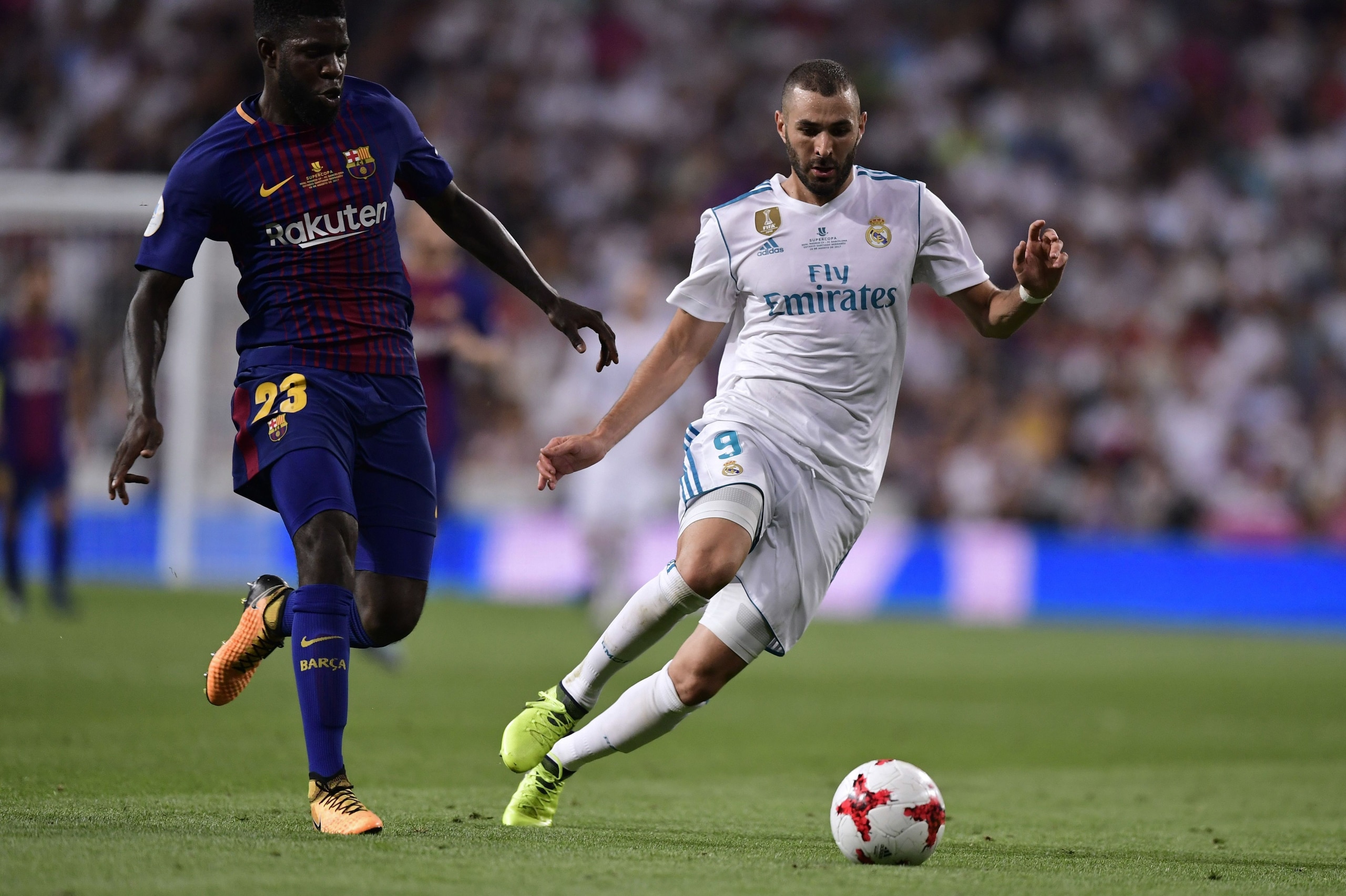 Barcelona's French defender Samuel Umtiti (L) vies with Real Madrid's French forward Karim Benzema during the second leg of the Spanish Supercup football match Real Madrid vs FC Barcelona at the Santiago Bernabeu stadium in Madrid, on August 16, 2017. / A