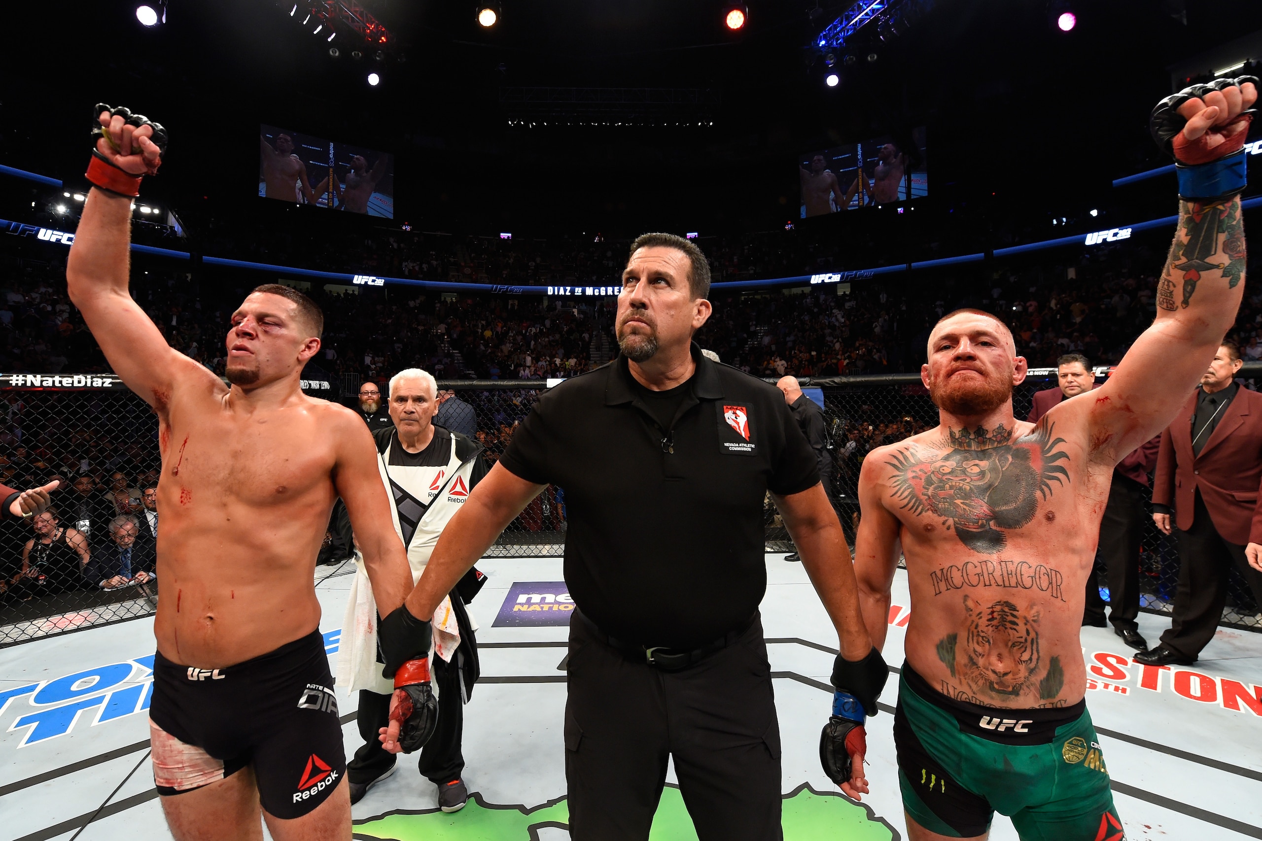 LAS VEGAS, NV - AUGUST 20:   (R-L) Conor McGregor of Ireland and Nate Diaz raise their hands and wait to hear the judges decision after their welterweight bout during the UFC 202 event at T-Mobile Arena on August 20, 2016 in Las Vegas, Nevada. (Photo by J