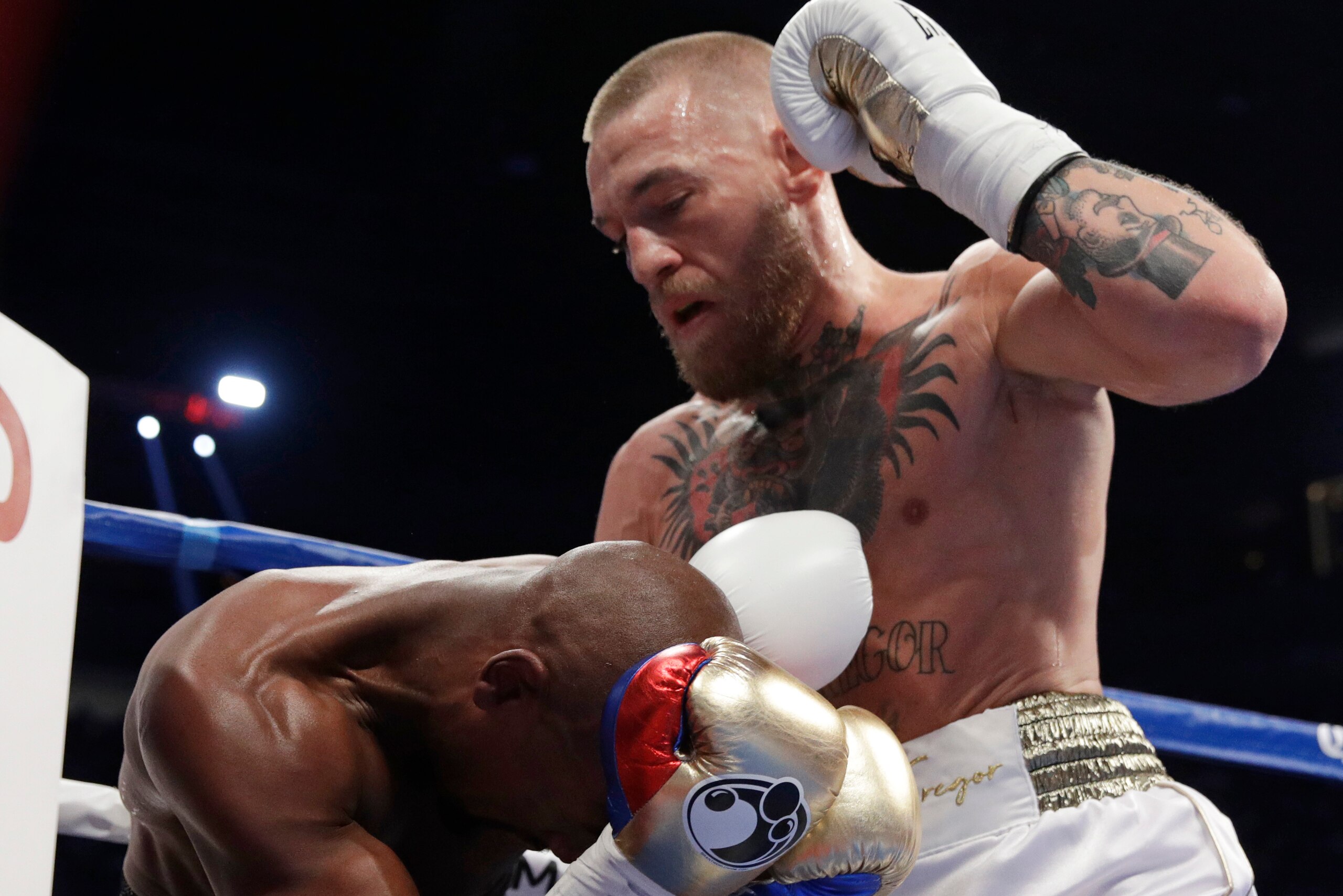 McGregor prepares to deliver a hammer fist blow to the back of Mayweather's head. McGregor prepares to deliver a hammer fist blow to the back of Mayweather's head.