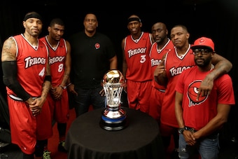 SEATTLE, WA - AUGUST 20:  Kenyon Martin #4, James White #8, head coach Rick Mahorn, Al Harrington #3, Dion Glover #22, Rashad McCants #32 and assistant coach DeMarcus Bateman of the Trilogy pose for a trophy after winning the semifinals against the Ghost 