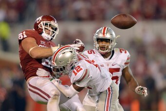 NORMAN, OK - SEPTEMBER 17: Tight end Mark Andrews #81 of the Oklahoma Sooners has the ball knocked out of his hands after getting hit by cornerback Denzel Ward #12 in front of linebacker Chris Worley #35 of the Ohio State Buckeyes on September 17, 2016 at