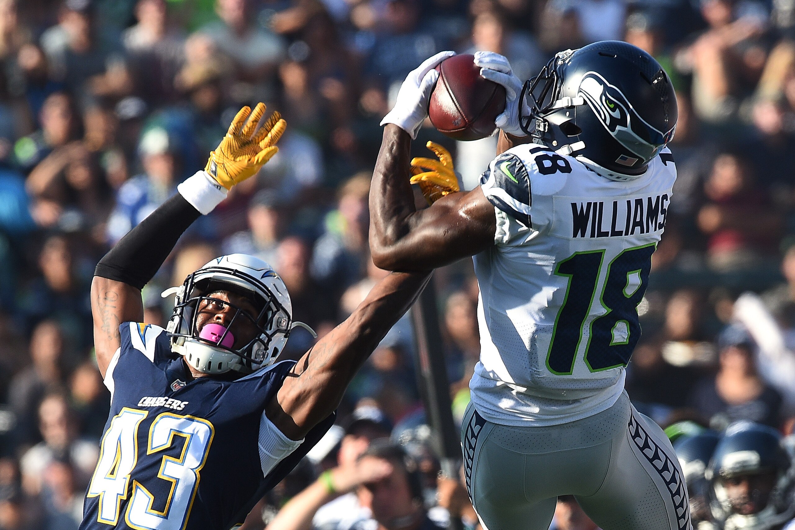 CARSON, CA - AUGUST 13: Kasen Williams #18 of the Seattle Seahawks catches a pass against cornerback Michael Davis #43 of the Los Angeles Chargers during the second quarter of their pre season football game at the StubHub Center August 13, 2017, in Carson