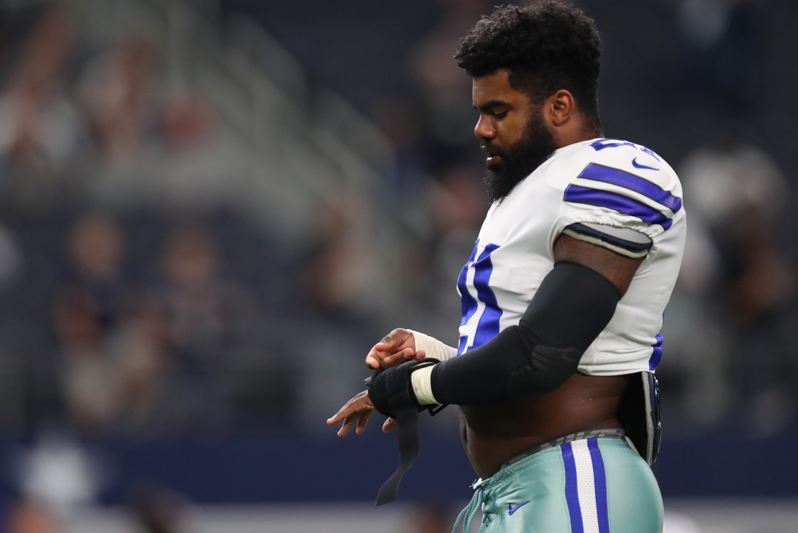 ARLINGTON, TX - AUGUST 26: Ezekiel Elliott #21 of the Dallas Cowboys wraps his hands on the field during warmups in a preseason game against the Oakland Raiders at AT&T Stadium on August 26, 2017 in Arlington, Texas. (Photo by Tom Pennington/Getty Images) ARLINGTON, TX - AUGUST 26: Ezekiel Elliott #21 of the Dallas Cowboys wraps his hands on the field during warmups in a preseason game against the Oakland Raiders at AT&T Stadium on August 26, 2017 in Arlington, Texas. (Photo by Tom Pennington/Getty Images)