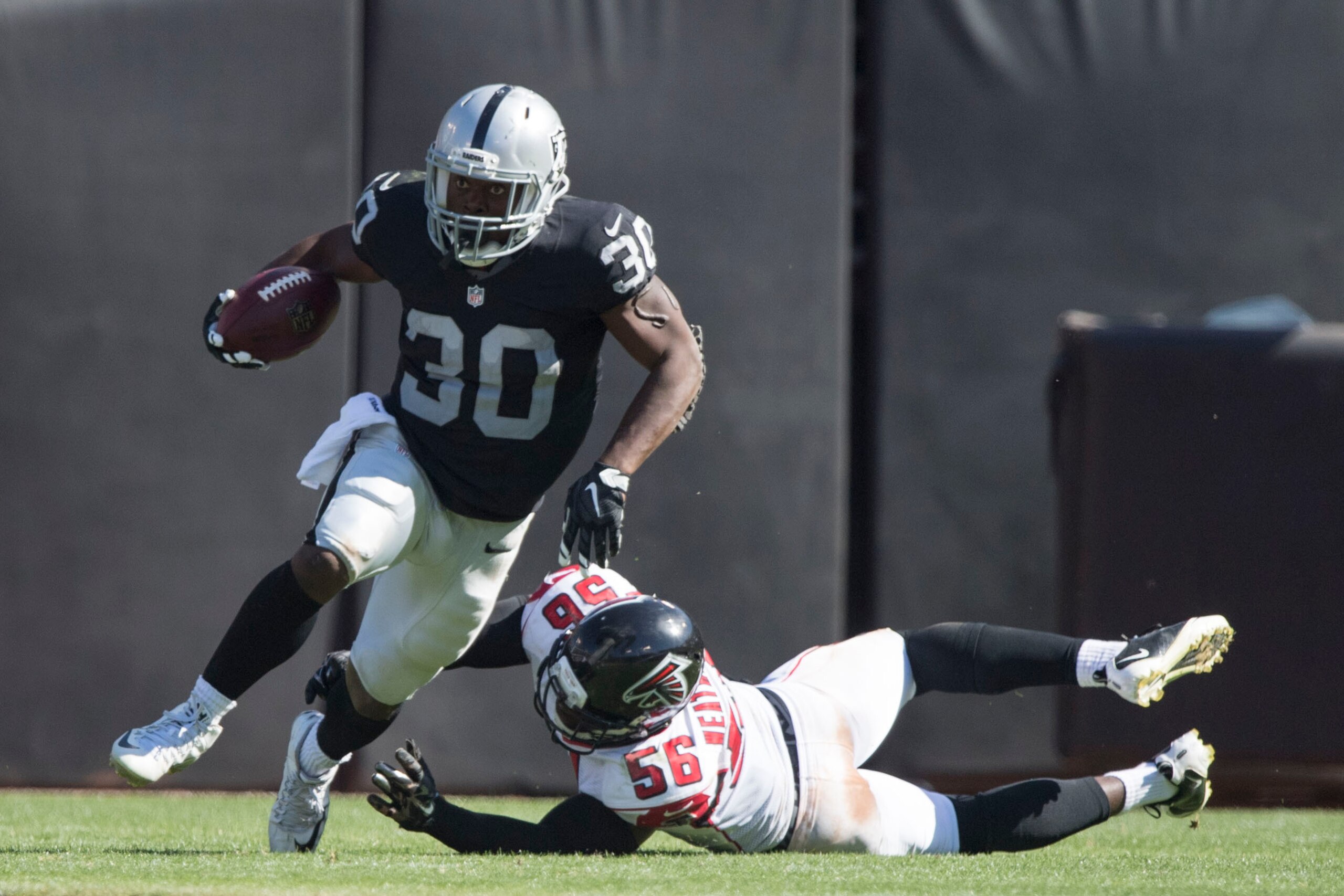 September 18, 2016; Oakland, CA, USA; Oakland Raiders running back Jalen Richard (30) runs with the football past Atlanta Falcons linebacker Sean Weatherspoon (56) during the third quarter at Oakland Coliseum. The Falcons defeated the Raiders 35-28. Manda