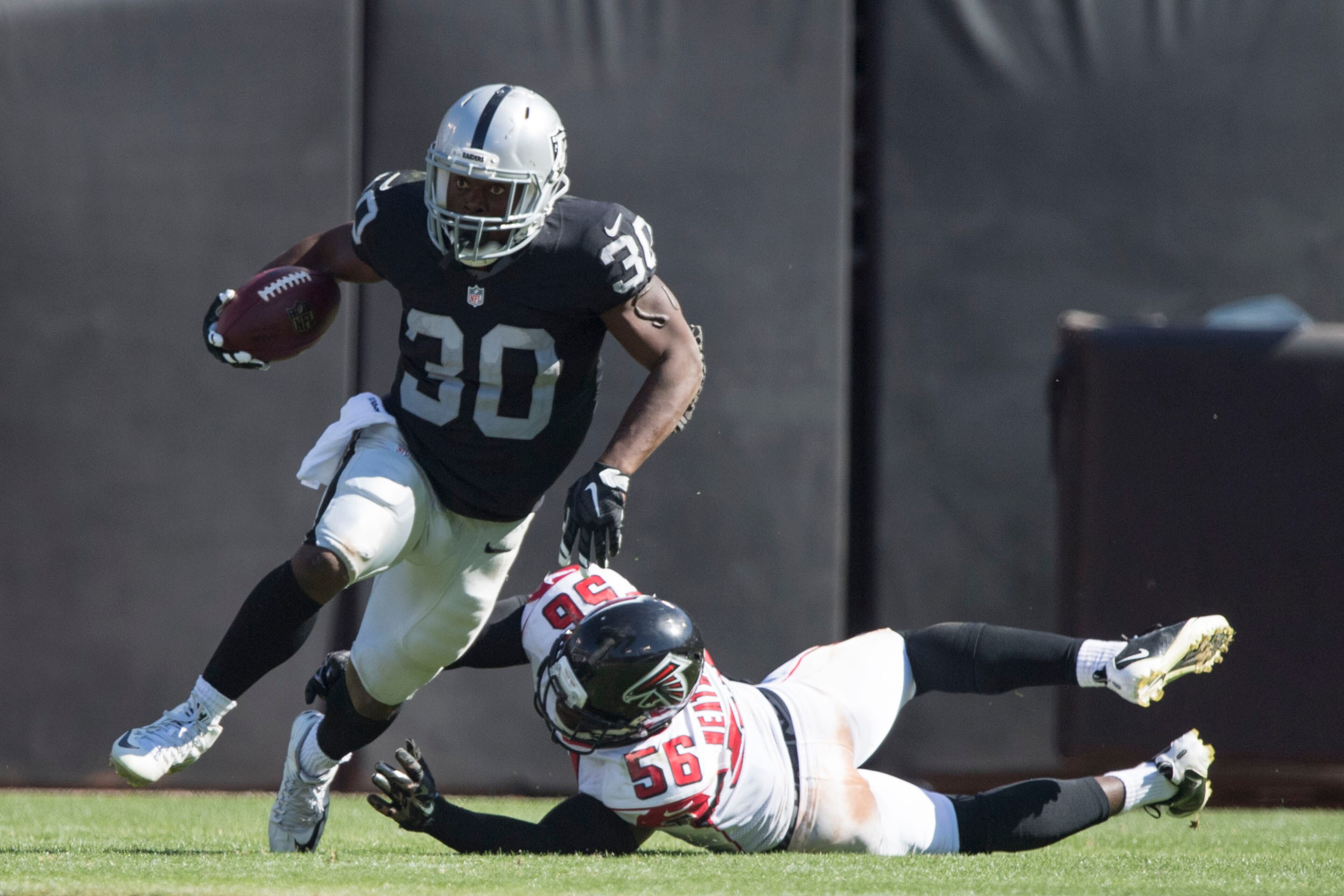 September 18, 2016; Oakland, CA, USA; Oakland Raiders running back Jalen Richard (30) runs with the football past Atlanta Falcons linebacker Sean Weatherspoon (56) during the third quarter at Oakland Coliseum. The Falcons defeated the Raiders 35-28. Manda