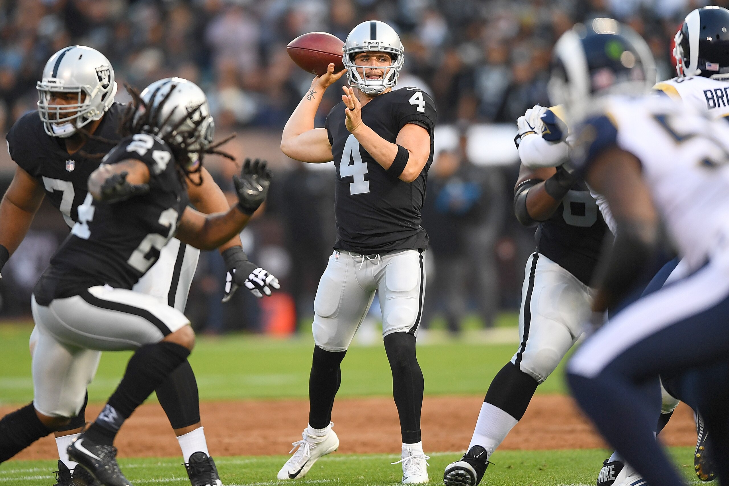 OAKLAND, CA - AUGUST 19:  Derek Carr #4 of the Oakland Raiders looks to throw a pass against the Los Angeles Rams during the first quarter of their preseason NFL football game at Oakland-Alameda County Coliseum on August 19, 2017 in Oakland, California.  
