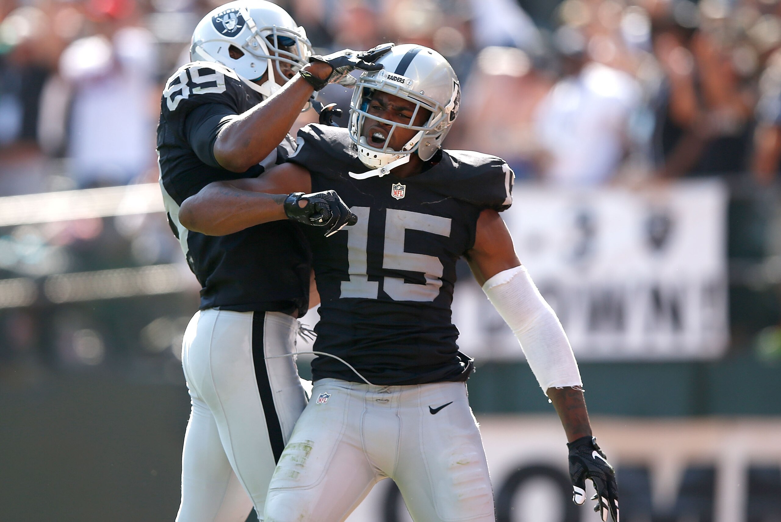 OAKLAND, CA - SEPTEMBER 20:  Michael Crabtree #15 of the Oakland Raiders celebrates a touchdown in the third quarter with Amari Cooper #89 of the Oakland Raiders against the Baltimore Ravens at Oakland-Alameda County Coliseum on September 20, 2015 in Oakl
