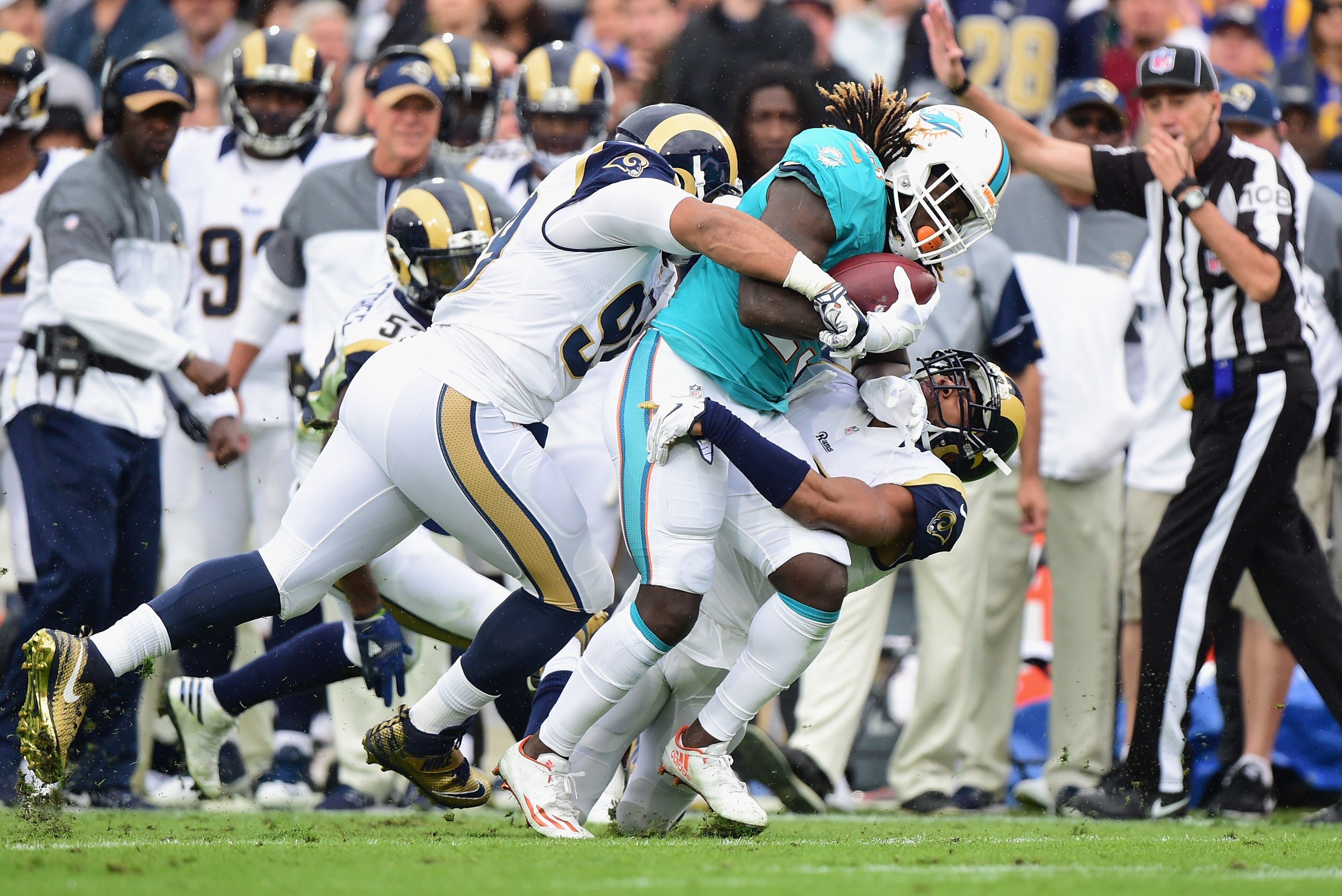 LOS ANGELES, CA - NOVEMBER 20:  T.J. McDonald #25 (R) and Aaron Donald #99 of the Los Angeles Rams tackles Jay Ajayi #23 of the Miami Dolphins during the first quarter of the game at Los Angeles Coliseum on November 20, 2016 in Los Angeles, California.  (