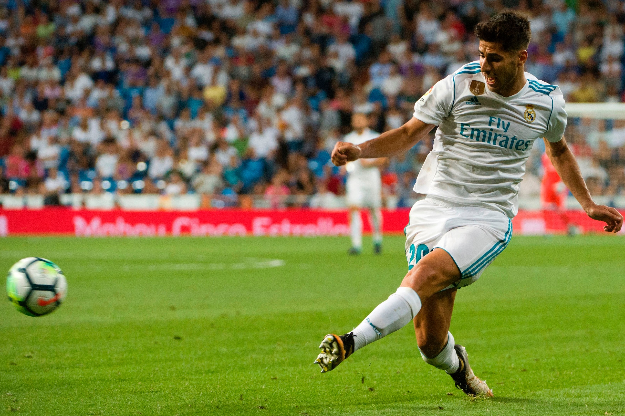 Real Madrid's midfielder Marco Asensio kicks the ball during the Spanish league football match Real Madrid CF vs Valencia CF at the Santiago Bernabeu stadium in Madrid on August 27, 2017.
The game ended with a draw 2-2. / AFP PHOTO / CURTO DE LA TORRE    