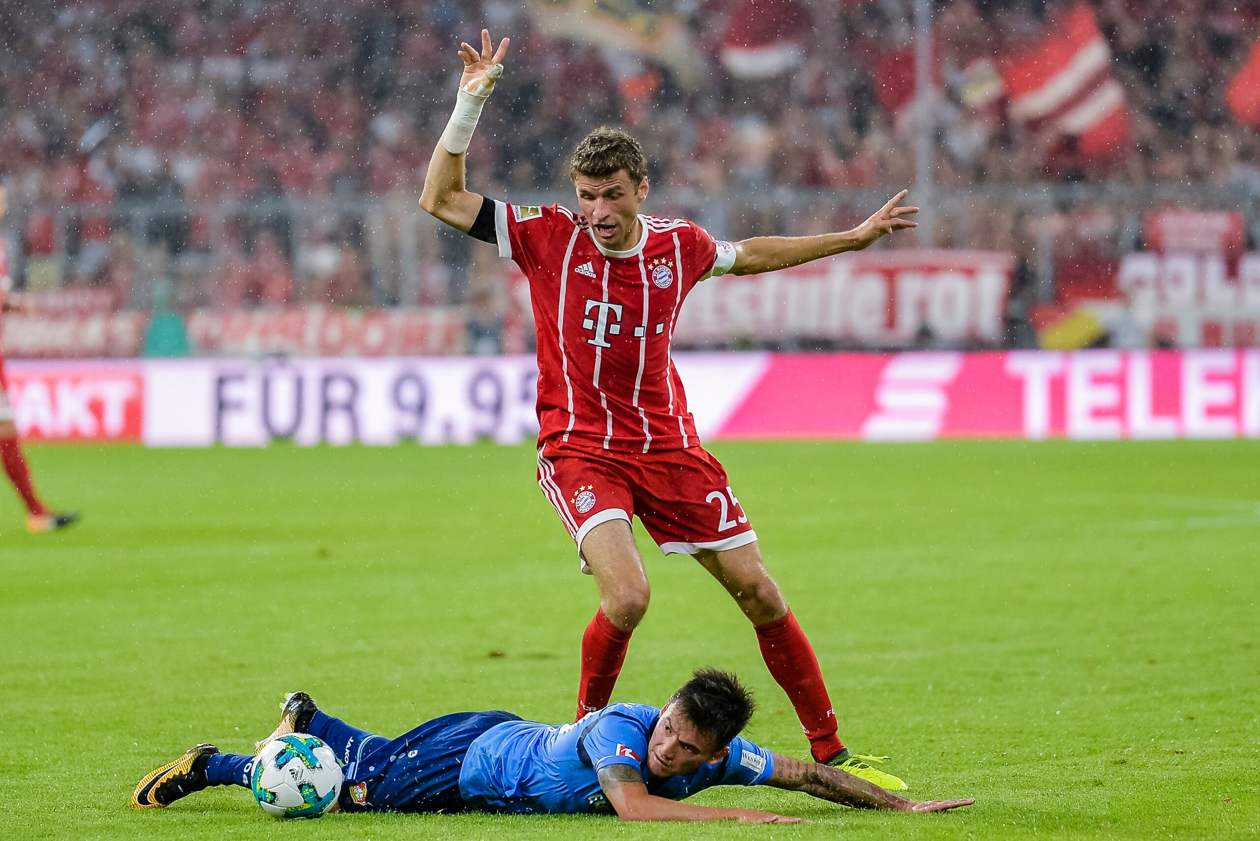 Bayern Munich's German striker Thomas Mueller and Leverkusen's Chilian midfielder Charles Aranguiz vie for the ball during the German First division Bundesliga football match FC Bayern Munich vs Bayer 04 Leverkusen in Munich, southern Germany, on August 1