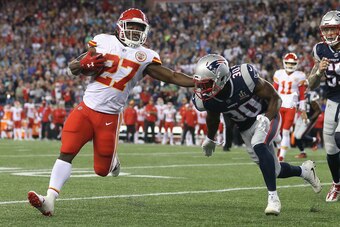 FOXBORO, MA - SEPTEMBER 07:  Kareem Hunt #27 of the Kansas City Chiefs stiff arms Duron Harmon #30 of the New England Patriots as he runs for a 4-yard rushing touchdown during the fourth quarter against the New England Patriots at Gillette Stadium on Sept