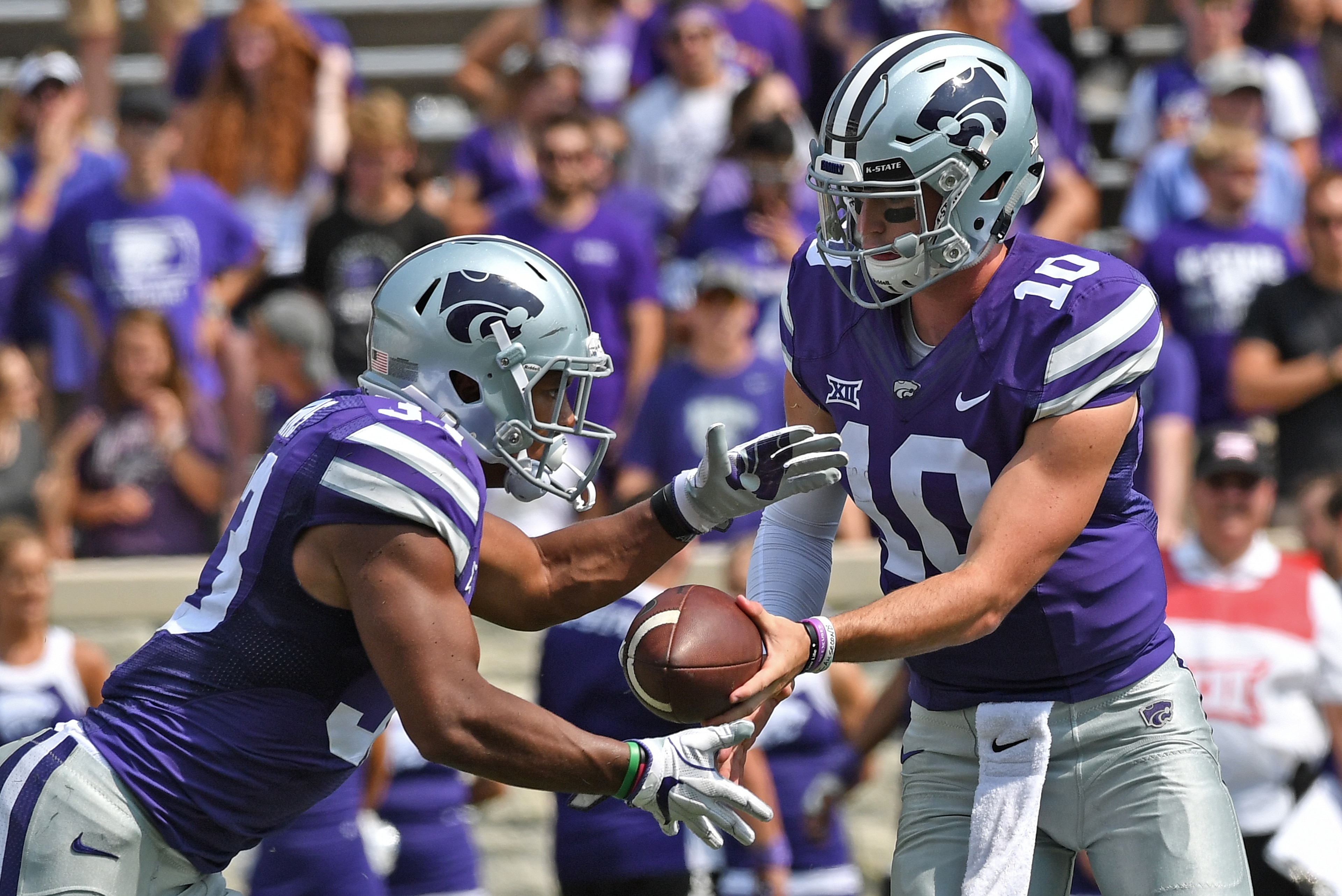 MANHATTAN, KS - SEPTEMBER 09:  Quarterback Alex Delton #10 of the Kansas State Wildcats hands the ball off to running back Tyler Burns #33 against the Charlotte 49ers during the second half on September 9, 2017 at Bill Snyder Family Stadium in Manhattan, 
