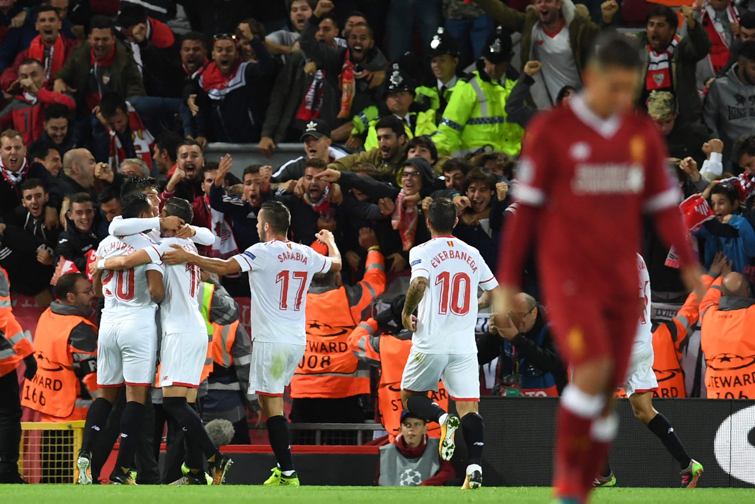 Sevilla's Argentinian midfielder Joaquin Correa celebrates with teammates after scoring during the UEFA Champions League Group E football match between Liverpool and Sevilla at Anfield in Liverpool, north-west England on September 13, 2017. / AFP PHOTO / 
