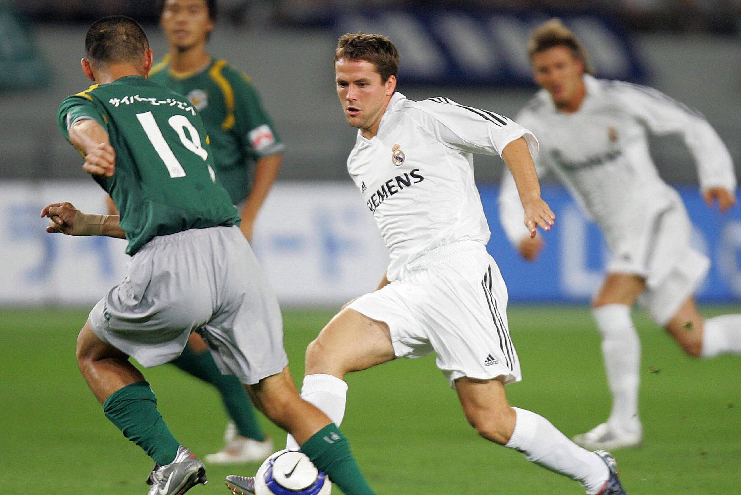 TOKYO, JAPAN:  British striker Michael Owen (C) of Real Madrid passes the ball past Japan's Tokyo Verdy 1969 defender Kenichi Uemura (L) during their football match at Tokyo Stadium, 25 July 2005.  J-League club Verdy were leading 2-0 against Real Madrid 