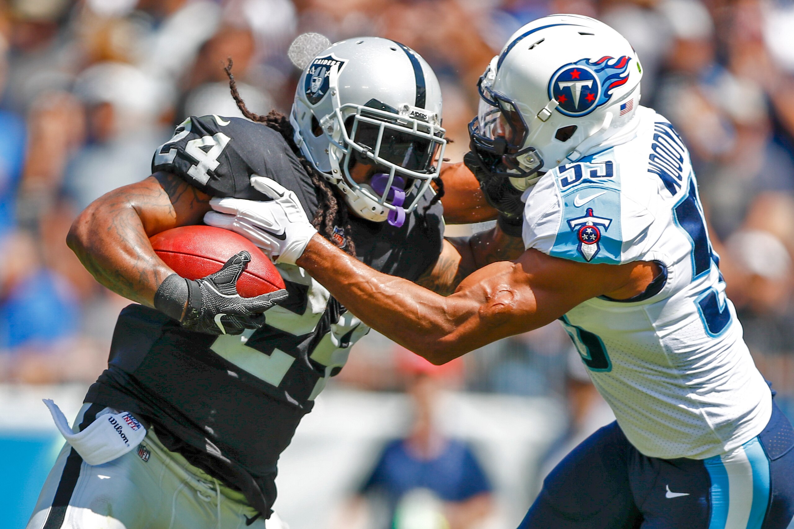 NASHVILLE, TN- SEPTEMBER 10: Running back Marshawn Lynch #24 of the Oakland Raiders stiff arms linebacker Jayon Brown  #55 of the Tennessee Titans in the first half at Nissan Stadium on September 10, 2017 In Nashville, Tennessee. (Photo by Wesley Hitt/Get