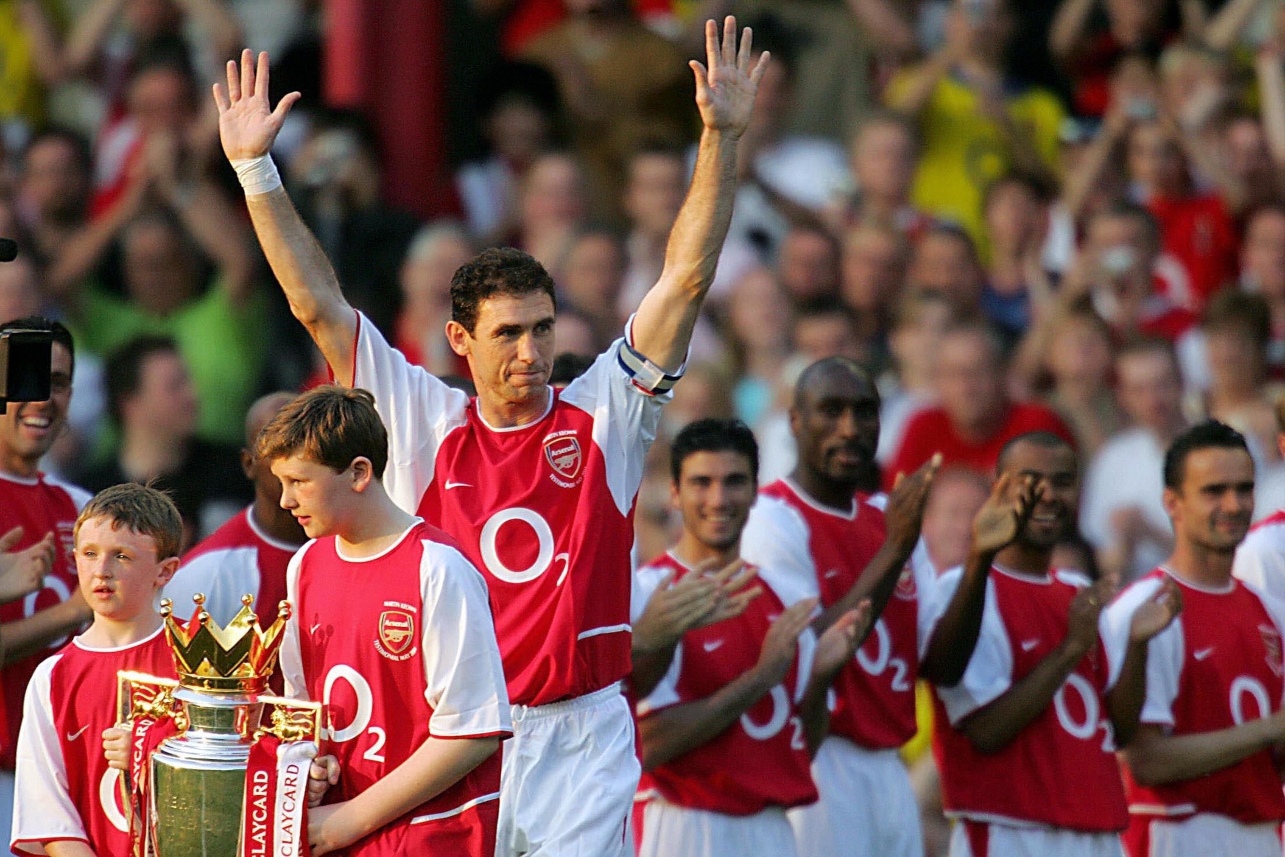 LONDON, UNITED KINGDOM:  Arsenal's Martin Keown with his sons Niall (L) and Callum (2ndL) raises his arms as he is being saluted by teammates  before kick off in a testimonial football  match for himself against England X1 at Highbury in north London, 17 