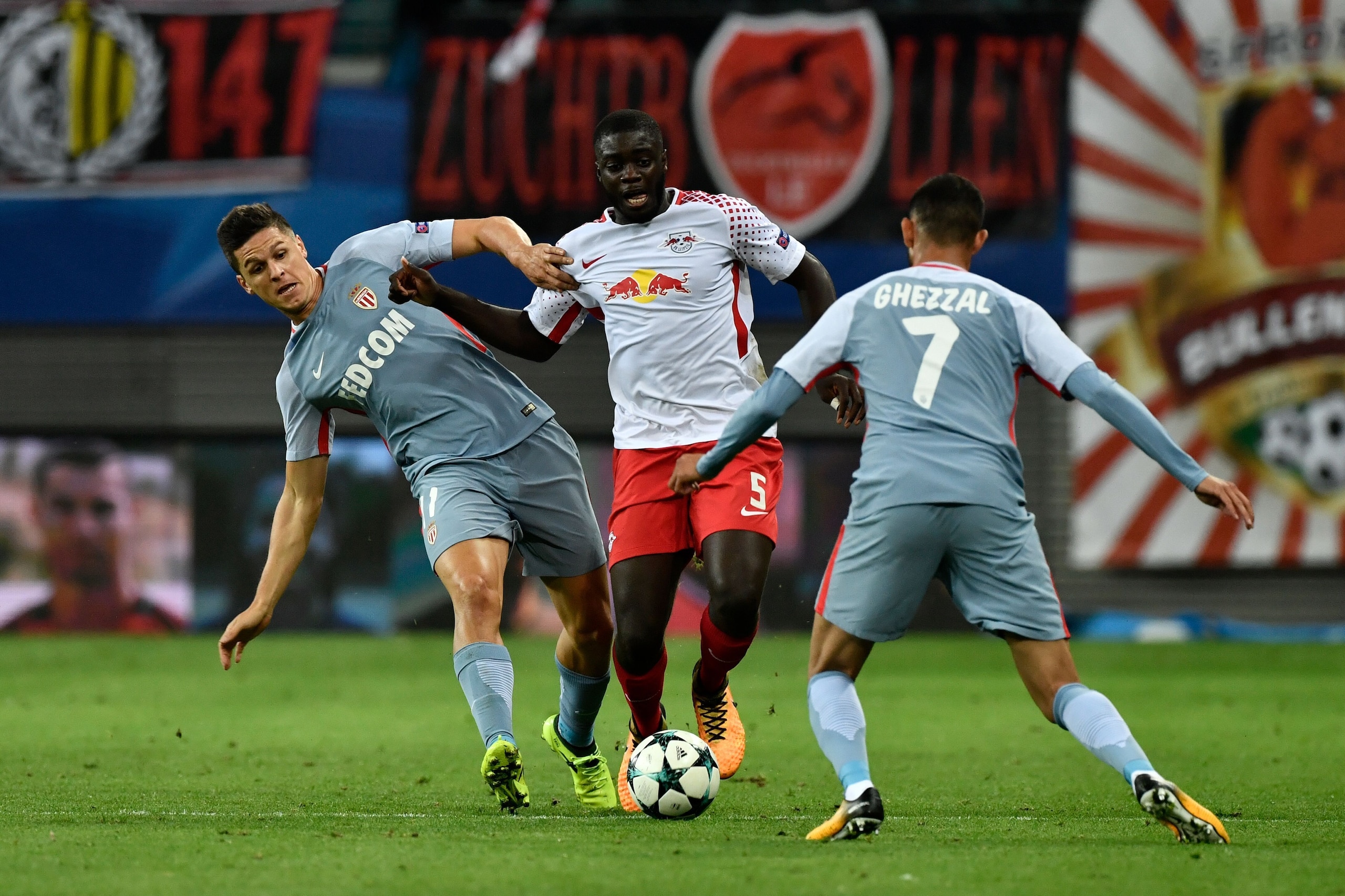 Leipzig's French defender Dayot Upamecano (C) is pressuded by Monaco's Argentinian forward Guido Carrillo (L) and Monaco's Algerian midfielder Rachid Ghezzal during the UEFA Champions League group G football match RB Leipzig v AS Monaco in Leipzig, easter