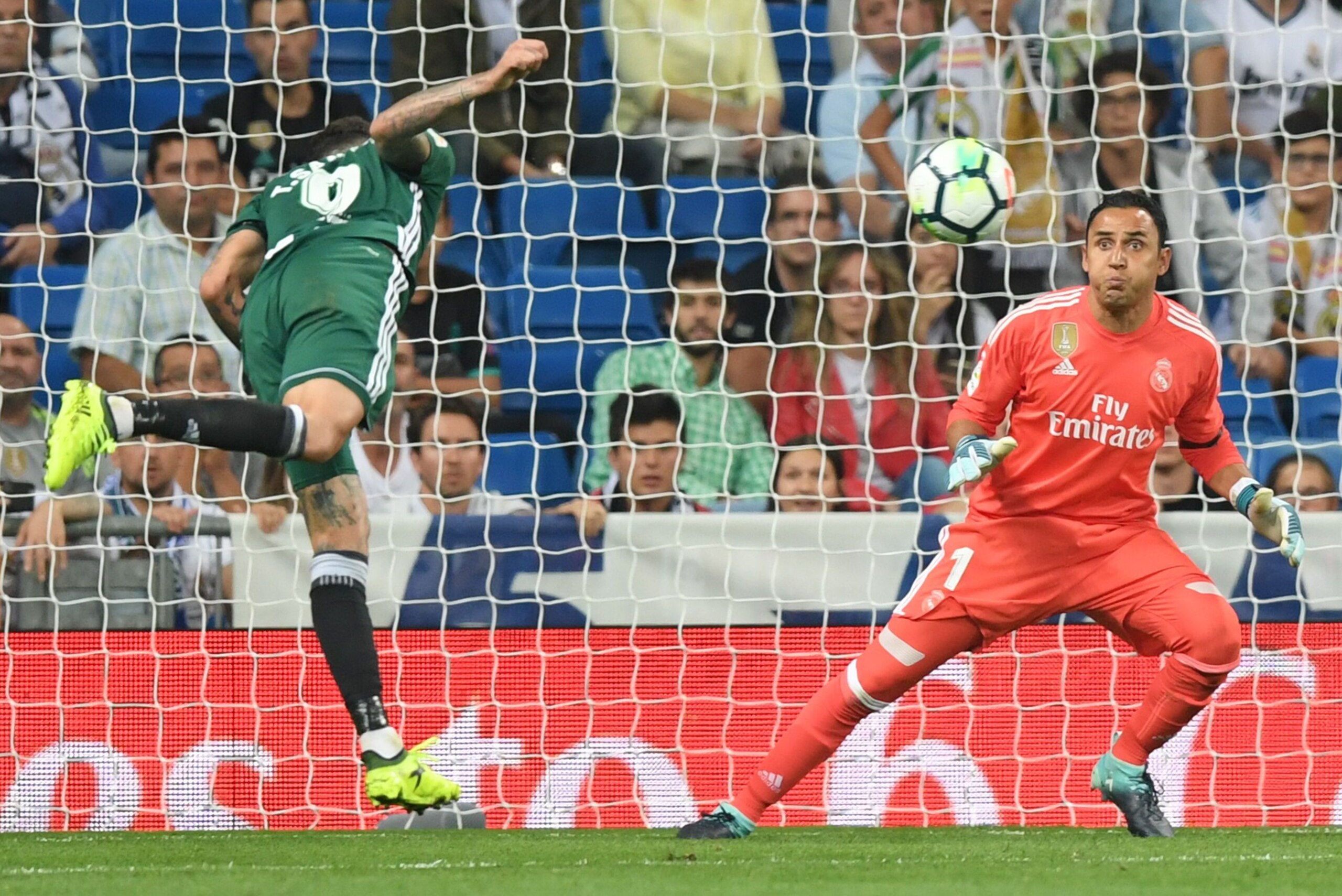 Real Betis' forward from Paraguay Arnaldo Sanabria (L) heads the ball, against Real Madrid's goalkeeper from Costa Rica Keylor Navas, to score a goal during the Spanish league football match Real Madrid CF against Real Betis  at the Santiago Bernabeu stad